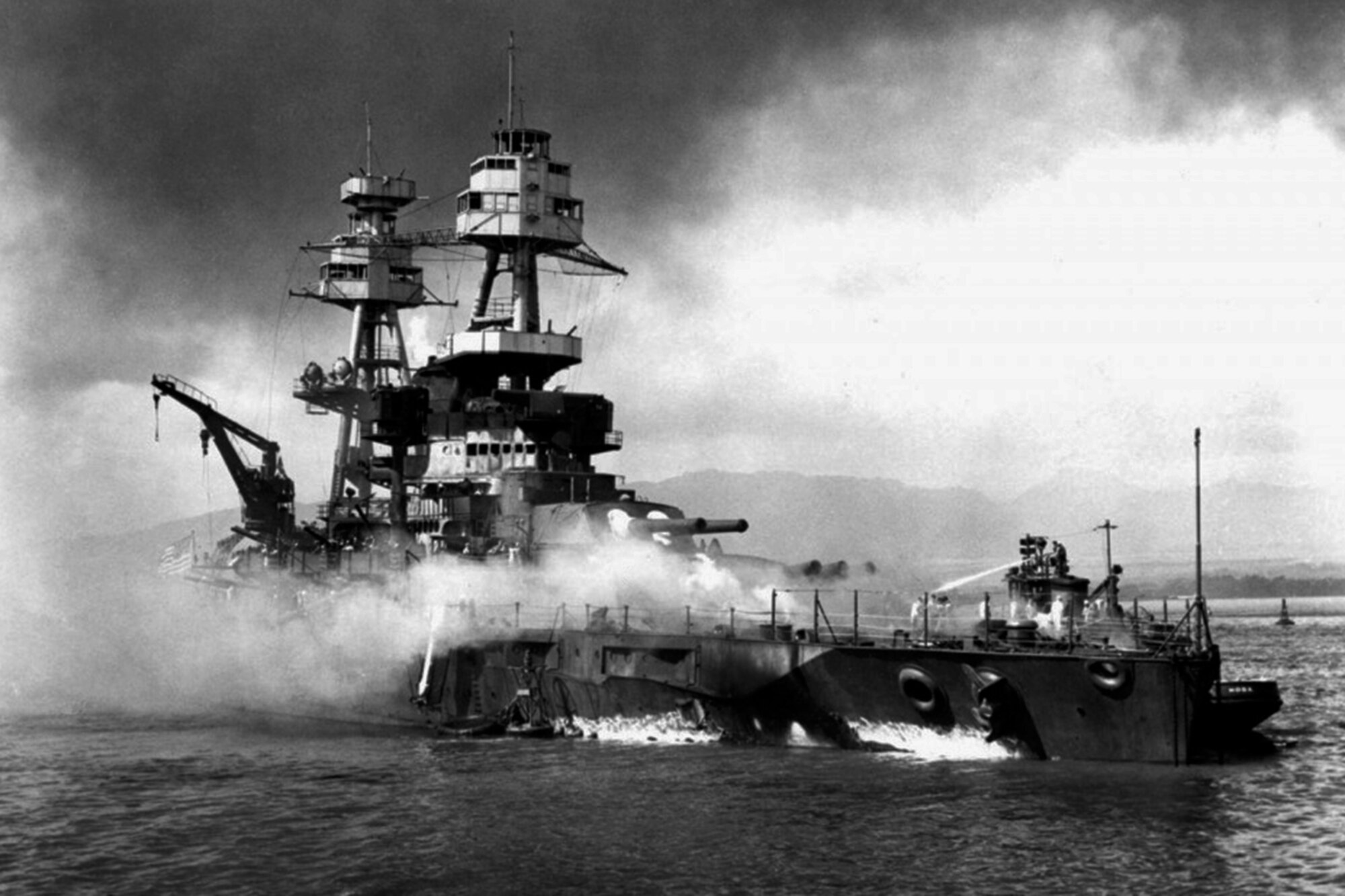 The crew of the USS Hoga (YT 146) fighting fires burning onboard the grounded battleship USS Nevada (BB-36) in Pearl Harbor, Dec. 7, 1941. The Nevada was the only U.S. battleship that got underway during the Pearl Harbor attack. The battered ship was salvaged and lived to fight again during the D-Day invasion of France and the battles of Iwo Jima and Okinawa. (National Archives photo 80-G-19940 - Courtesy photo Naval Historical Foundation)