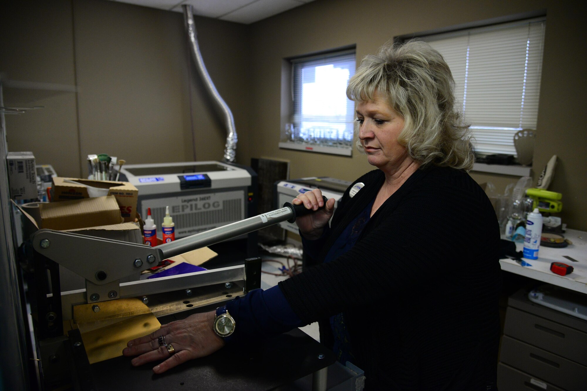 Sherry Pschernig, 341st Force Support Squadrons Arts and Crafts Center engraver, cuts a sheet of metal on a specialized machine Dec. 7, 2016, at Malmstrom Air Force Base, Mont. The Engraving Shop makes the majority of their products from scratch. (U.S. Air Force photo/Airman 1st Class Magen M. Reeves)