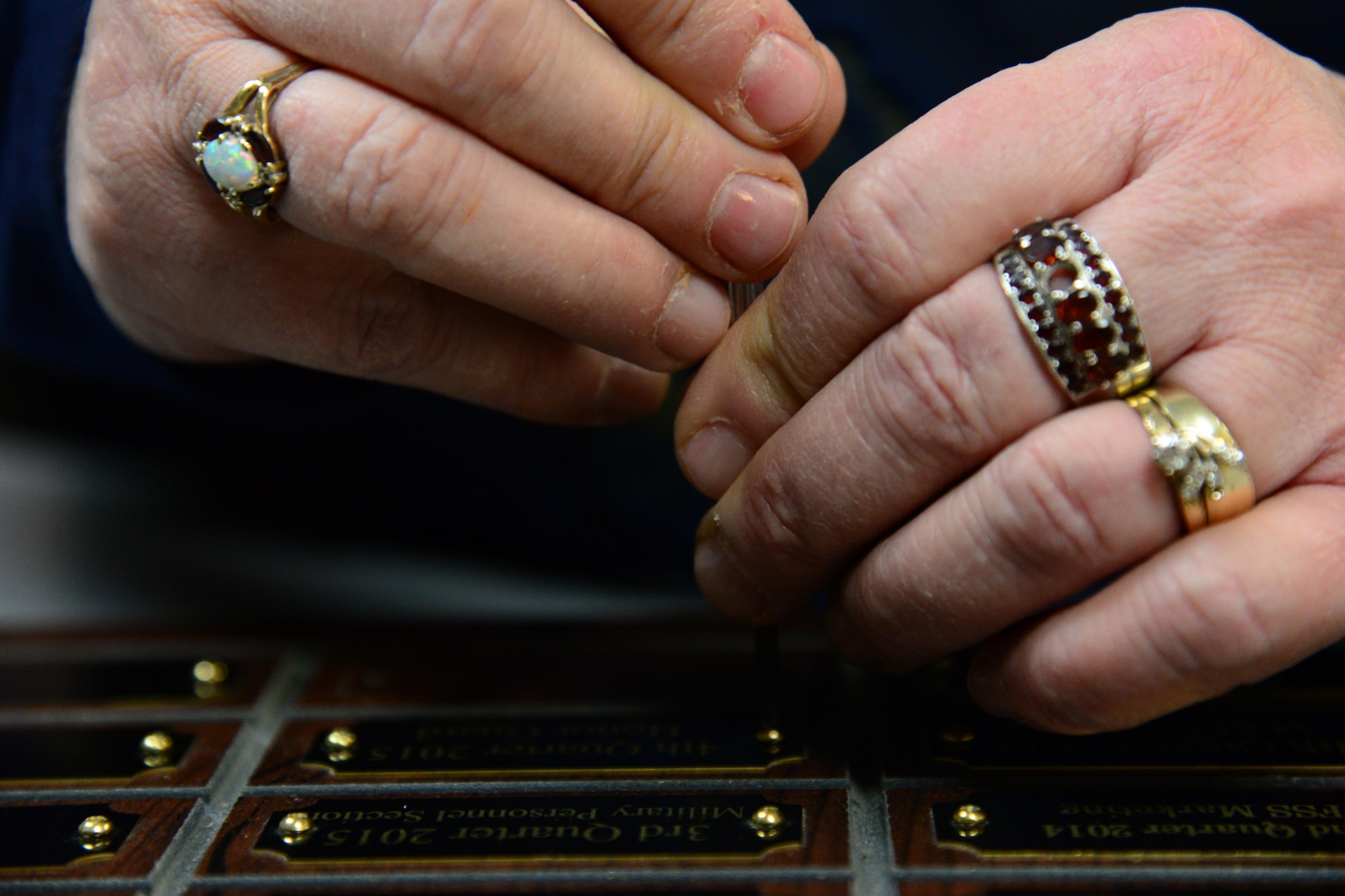 Sherry Pschernig, 341st Force Support Squadrons Arts and Crafts Center engraver, screws down a name plate Dec. 7, 2016, at Malmstrom Air Force Base, Mont. Pschernig is one of two individuals who work in the shop, where they make the majority of their products from scratch, to include wooden plaques, trophies and awards. (U.S. Air Force photo/Airman 1st Class Magen M. Reeves)
