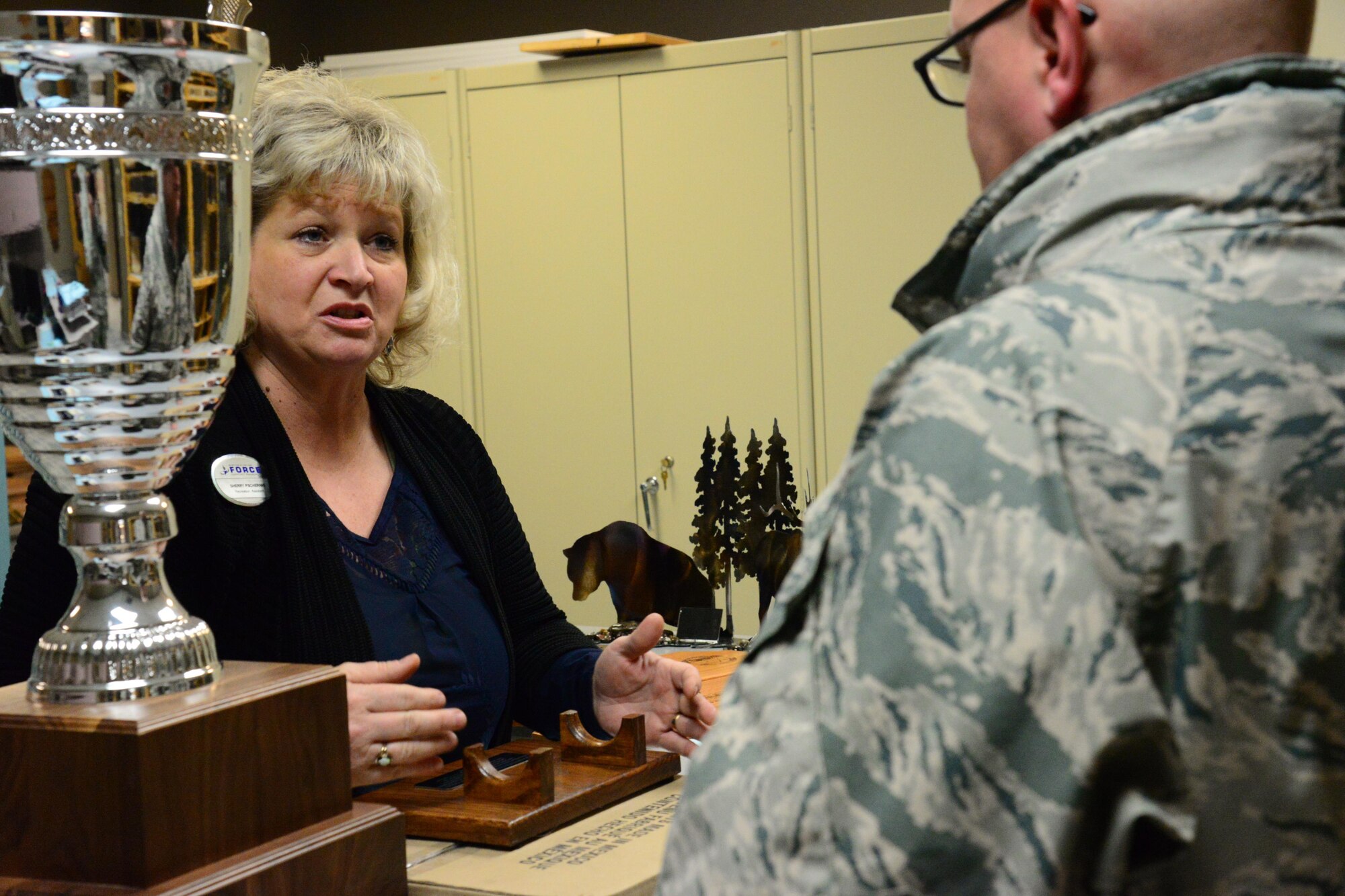 Sherry Pschernig, 341st Force Support Squadrons Arts and Crafts Center engraver, assists a customer Dec. 7, 2016, at Malmstrom Air Force Base, Mont. The Engraving Shop has the capability to make products from scratch to include wooden plaques, engraved glasses, acrylic, trophies, awards or knives to fit any customer’s needs. (U.S. Air Force photo/Airman 1st Class Magen M. Reeves)