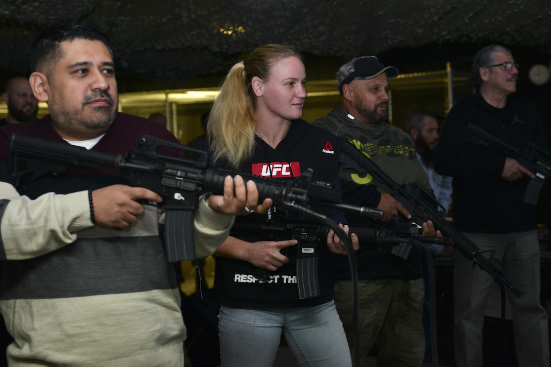 From left, Brian Garcia, MMAjunkie radio host, Valentina Shevchenko, UFC bantamweight fighter, Pavel Fedotov, Shevchenko’s coach, and Jacob Duran, professional cutman, operate Engagement Skills Trainer weapons during a visit to Joint Base Langley-Eustis, Va., Dec. 8, 2016. Shevchenko and UFC fighters Ben Rothwell, and Lorenz Larkin also met with U.S. Army Soldiers from the 7th Transportation Brigade (Expeditionary) and 690th Rapid Port Opening Element to discuss their different missions. (U.S. Air Force photo by Tech. Sgt. Katie Gar Ward)