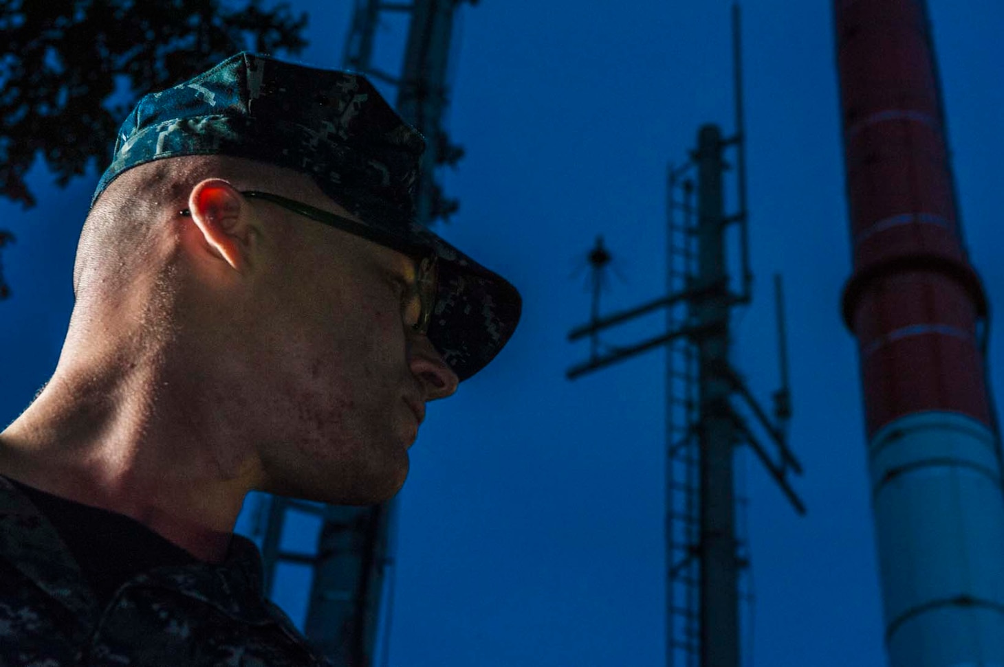 Petty Officer 2nd Class Brandon Armstrong, a meteorological forecaster, stands under the Automated Surface Observing System (ASOS) at the Naval Oceanography Anti-Submarine Warfare Center on Yokosuka Naval Base.