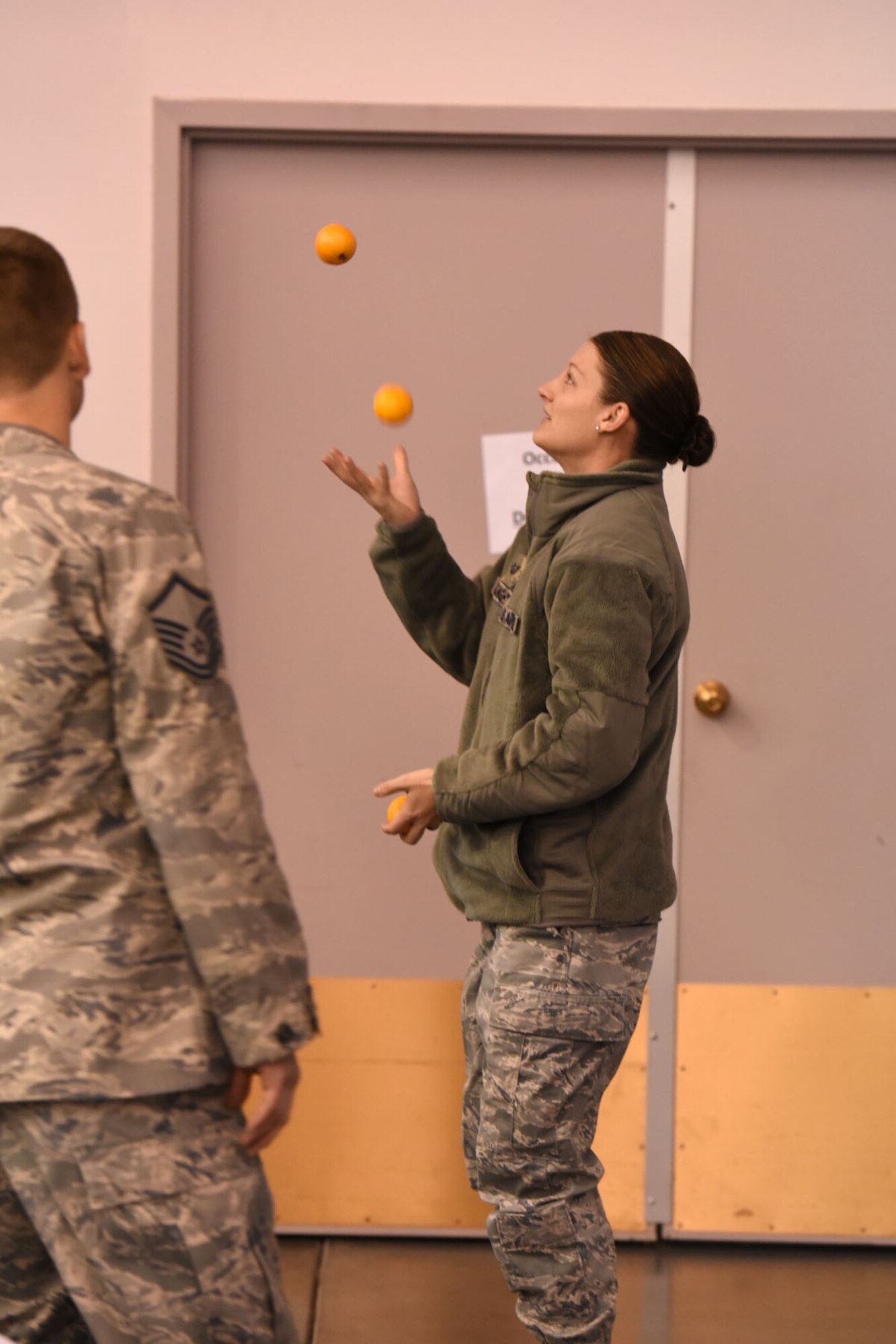 Tech. Sgt. Amanda McKnight, a 120th Security Forces Squadron security forces specialist, juggles oranges during a crowd participation exercise during the 120th Airlift Wing’s 2016 Wingman Day event December 3, 2016 at the Mansfield Center in Great Falls, Montana. The crowd participation exercise required individuals to share with their groups some unique fact about themselves. (U.S. Air National Guard photo/Master Sgt. Michael Touchette)