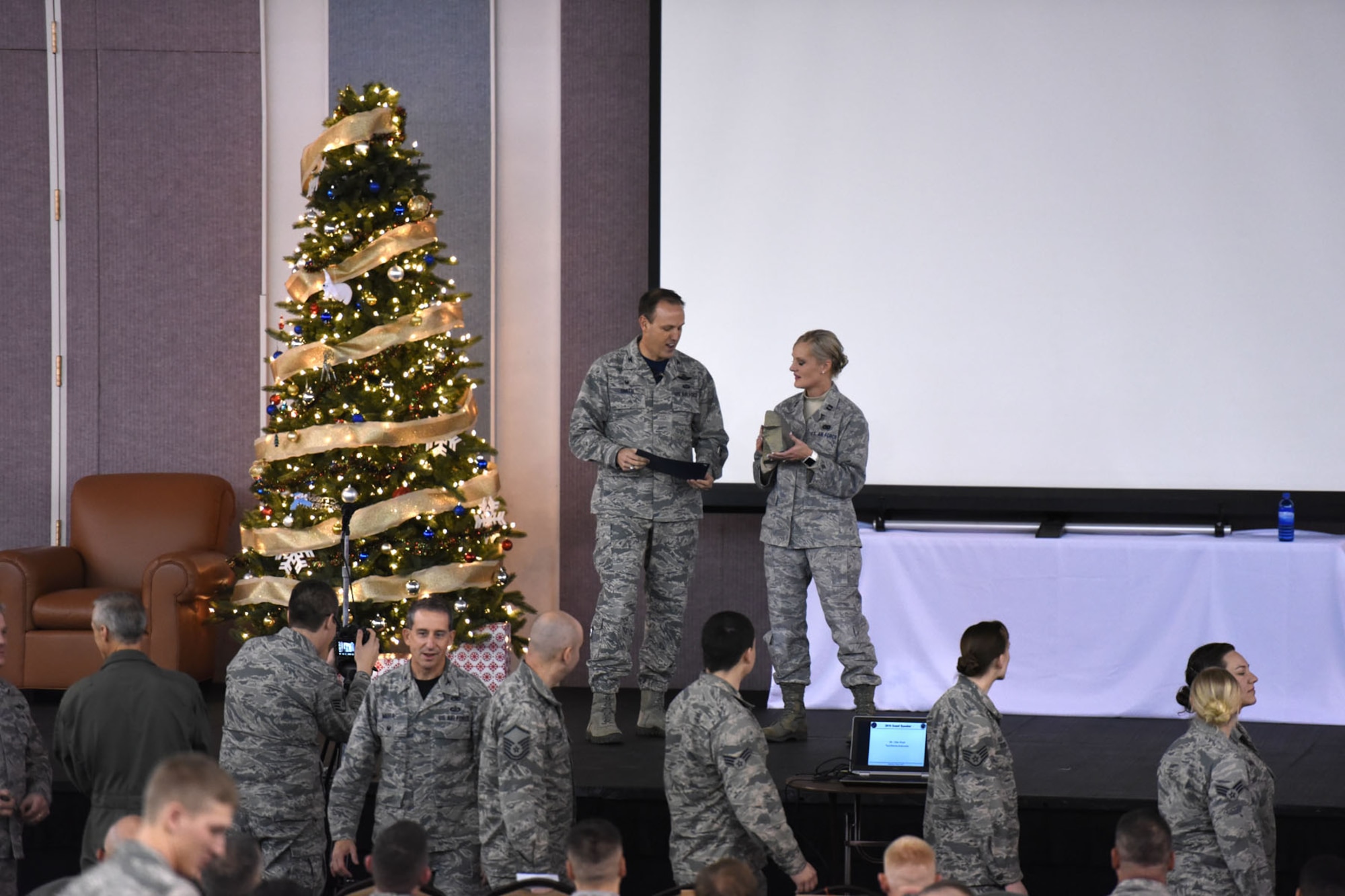 120th Airlift Wing Commander Col. Lee Smith presents Capt. Diane Labuda with a rock and certificate recognizing her as the unit’s rock, paper and scissors champion. Nearly 500 Guardsmen participated in the game during an audience participation exercise during the unit’s 2016 Wingman Day event December 3, 2016. (U.S. Air National Guard photo/Master Sgt. Michael Touchette)