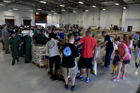 Operation Christmas Drop volunteers pack boxes Dec. 3, 2016, at Andersen Air Force Base, Guam. Over 200 volunteers packed clothes, rice, fish hooks, school supplies and more to be dropped over 50 islands throughout the Pacific. (U.S. Air Force photo by SrA Alexa Henderson/Released)