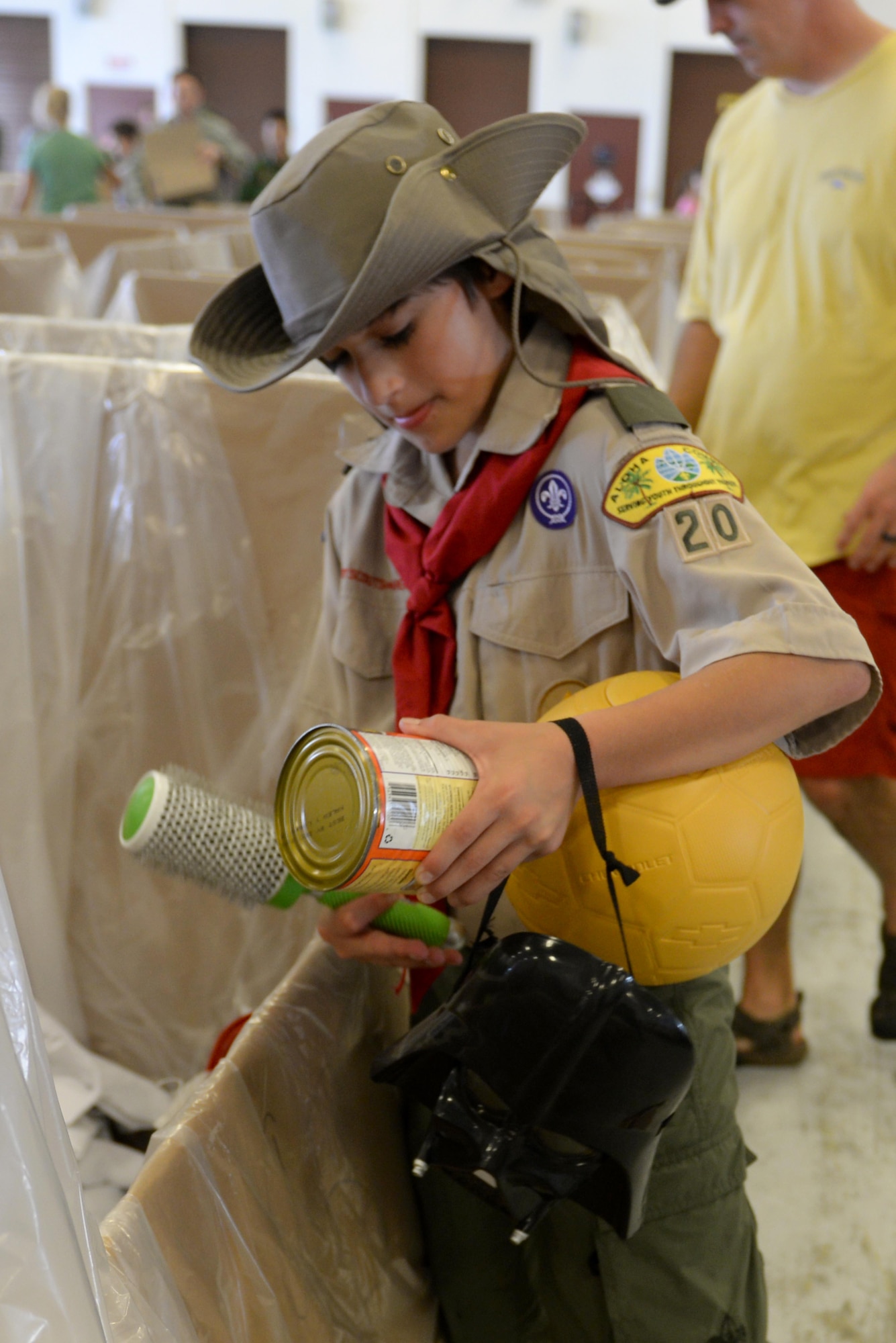 A volunteer packs canned goods, toys and necessities into a box during the Operation Christmas Drop packing party Dec. 3, 2016, at Andersen Air Force Base, Guam. Over 200 volunteers packed clothes, rice, fish hooks, school supplies and more into boxes to be dropped to over 50 islands throughout the Pacific. (U.S. Air Force photo by SrA Alexa Henderson/Released)