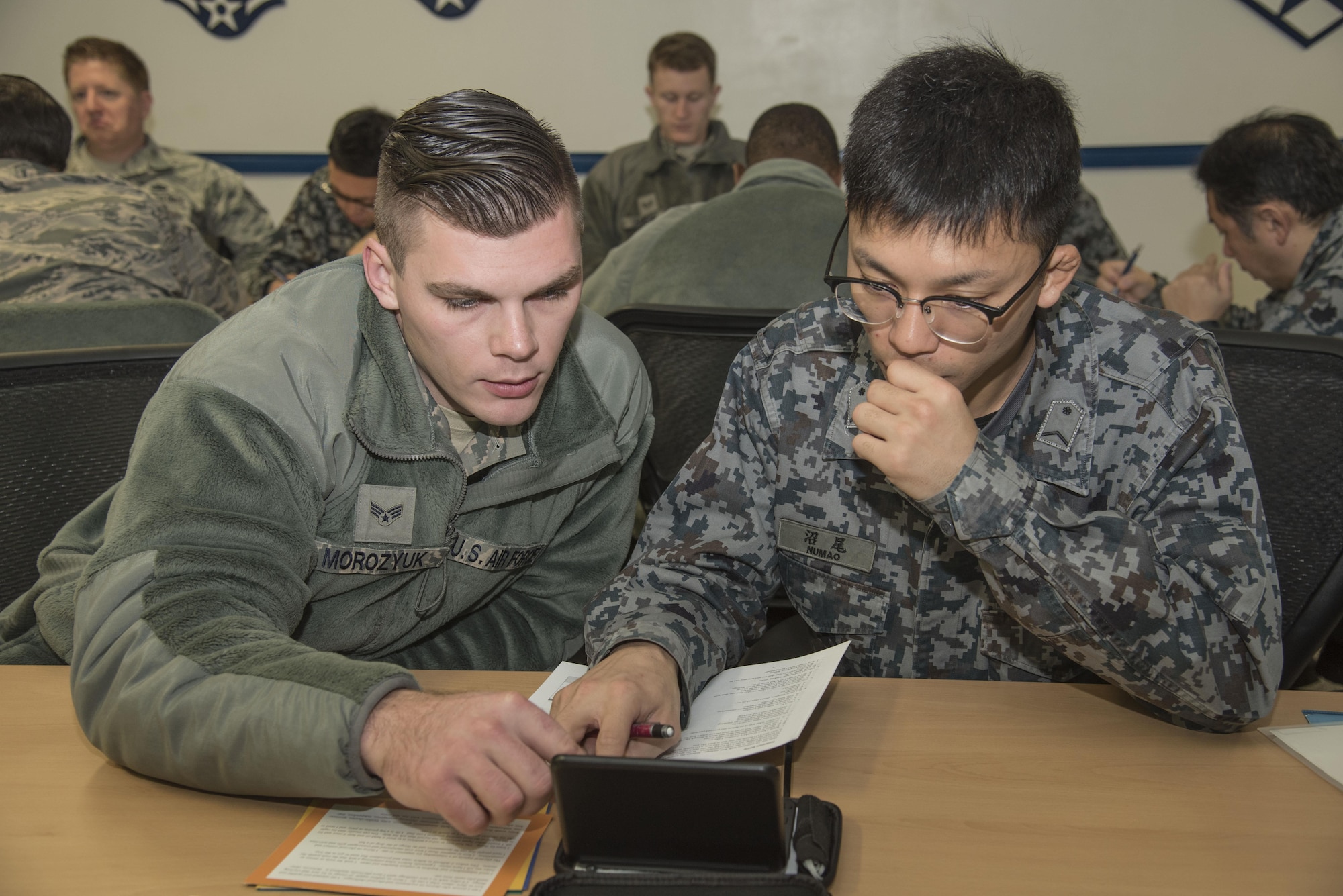 U.S. Air Force Senior Airman Kostyantyn Morozyuk, a 14th Aircraft Maintenance Unit crew chief, works with Japan Air Self-Defense Force Staff Sgt. Tomoyuki Numao, a 3rd Air Wing crew chief, during a "4 Lenses" exercise at Misawa Air Base, Japan, Nov. 30, 2016. The "4 Lenses" test is a proven personality assessment which helps organizations build understanding of the innate talent and potential of its individuals. Airmen and JASDF members were given a chance to work around language barriers while getting to know each other prior to working together during a bilateral exchange. (U.S. Air Force photo by Airman 1st Class Sadie Colbert)