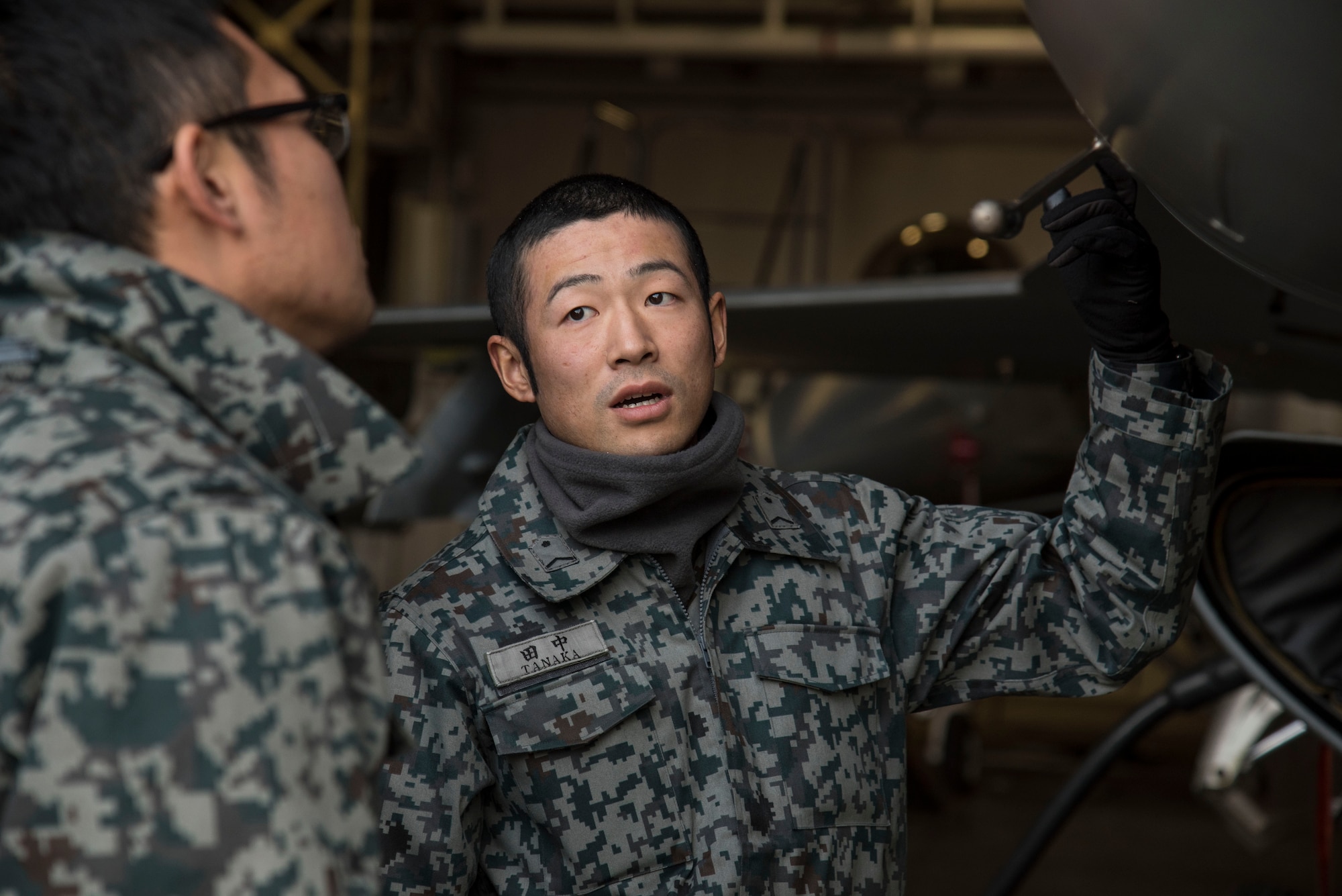 Japan Air Self-Defense Force Staff Sgts. Kenta Okazaki, left, and Narihito Tanaka, right, both 3rd Air Wing avionics technicians, discuss the proper aircraft procedures they would take for a downed aircraft at Misawa Air Base, Japan, Dec. 7, 2016. Airmen and JASDF service members participated in a bilateral exchange during a surge to gain insight on a deployed operations tempo. (U.S. Air Force photo by Airman 1st Class Sadie Colbert)