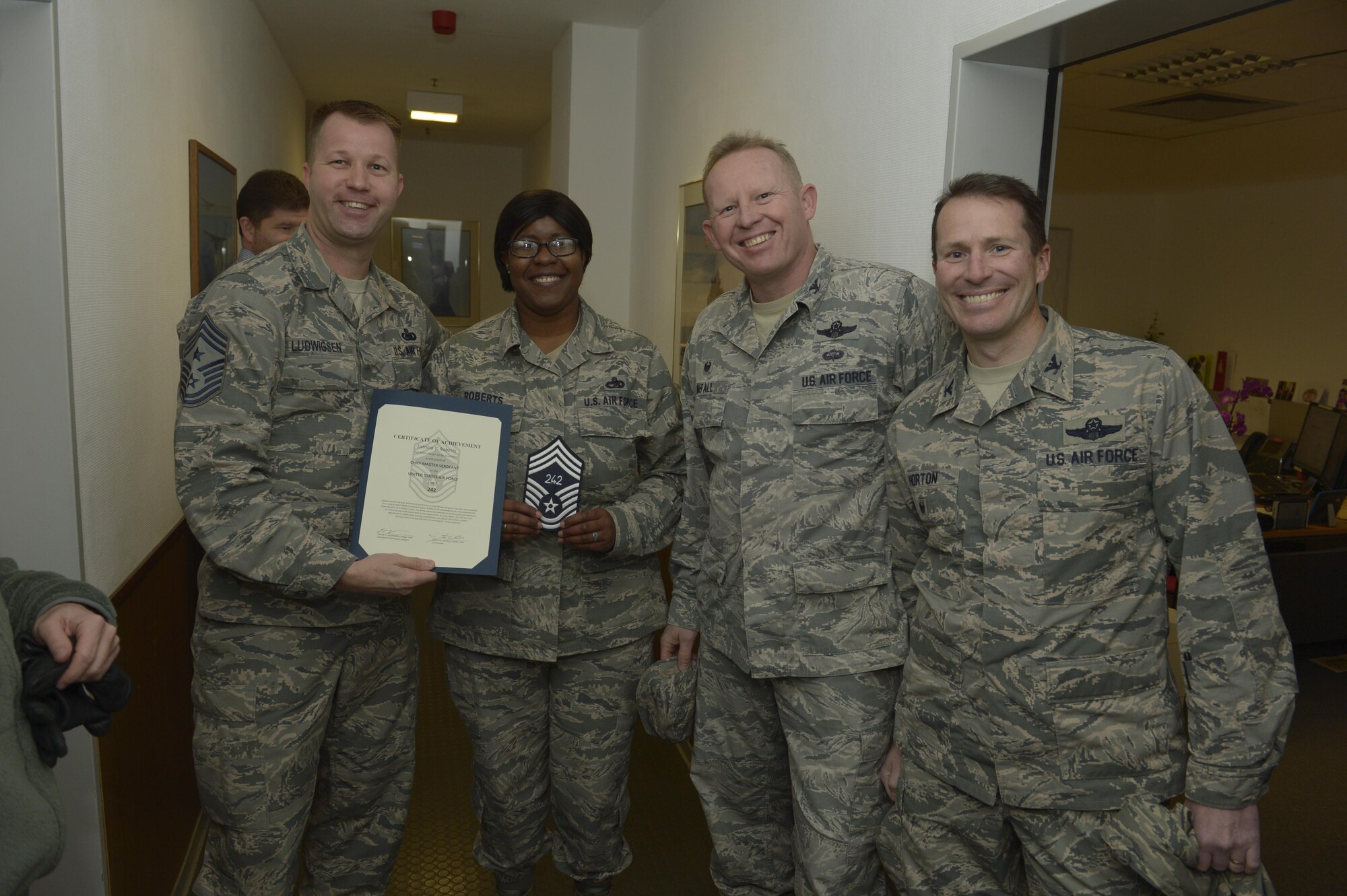 Senior Master Sgt. Latrica Roberts, center left, 52nd Logistic Readiness Squadron traffic management flight superintendent, receives notification she has been selected for promotion to chief master sergeant from Col. Joe McFall, center right, 52nd Fighter Wing commander, Col. Steven Horton, right, 52FW vice commander, and Chief Master Sgt. Edwin Ludwigsen, left, 52FW command chief, at Spangdahlem Air Base, Germany, Dec. 7, 2016. The selected senior master sergeant will later be inducted into the top one percent of the Air Force's enlisted ranks. (U.S. Air Force photo by Staff Sgt. Jonathan Snyder)
