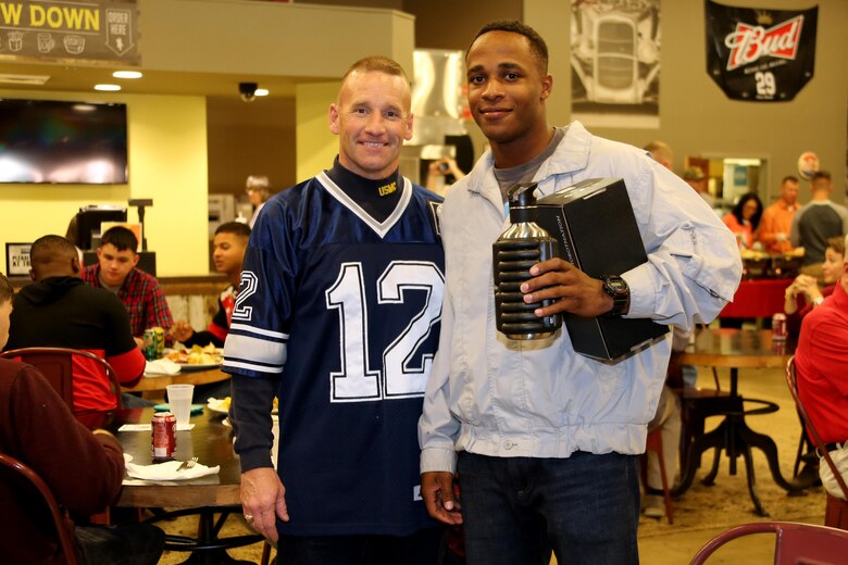 Sgt. Maj. Richard Thresher, left, poses for a photo with raffle winner Pfc. Jarod Bargainer during the Single Marine Program’s annual Thanksgiving Dinner at Marine Corps Air Station Cherry Point, N.C., Nov. 24, 2016. The Cherry Point Officers’ Spouse’s club and Enlisted Spouses Club of MCAS Cherry Point sponsored the event which distributed over six-hundred plates of food. Volunteers from Marine Corps Community Services and the Marine Corps League served Marines and their family members a full-course meal and desserts. Thresher is the sergeant major for the 2nd Marine Aircraft Wing and Bargainer is a student with the Center for Naval Aviation Technical Training. (Marine Corps photo by Cpl. Jason Jimenez/Released)