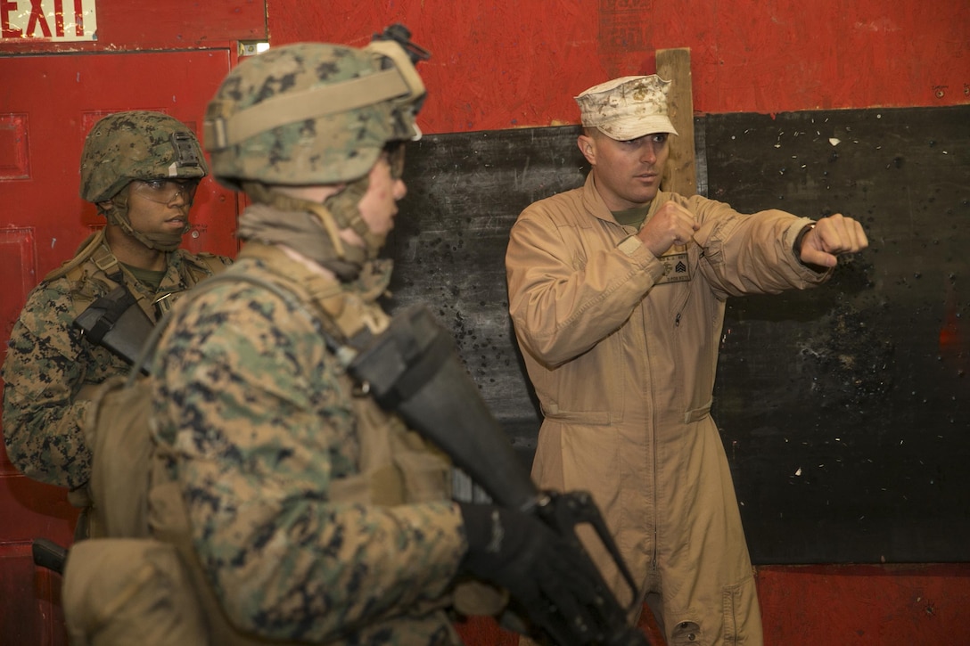 Sgt. Sean Litchfield, assistant team leader, Training Co., Marine Corps Security Forces Regiment, discusses proper techniques with a fire team during the Advanced Interior Tactics course Dec. 7, aboard Naval Support Activity Northwest Annex, Chesapeake, Va. Students in the course were taught key points on clearing rooms, identifying threats and maintaining control of objectives during the course. The two-week course also featured advanced marksmanship techniques applicable to room-clearing tactics. (Official Marine Corps photo by Sgt. Kayla D. Rivera/Released)