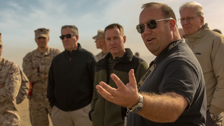 Casey Harsh, requirements analyst, Marine Corps Expeditionary Energy Office, explains different efforts and technologies the Marine Corps has developed during the Energy Capability Exercise, in alignment with the Great Green Fleet initiative, at Camp Wilson aboard the Marine Corps Air Ground Combat Center, Twentynine Palms, California, Dec. 6, 2016.