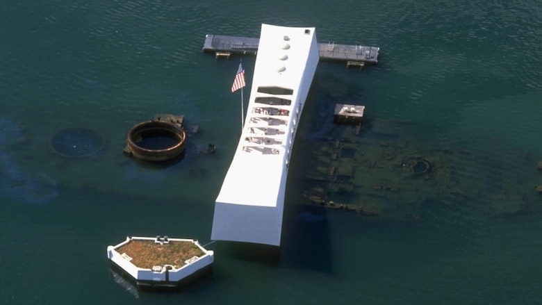 The USS Arizona Memorial, dedicated in 1962, straddles the remains

of the battleship sunk during the surprise Japanese air attack, Dec.

7, 1941. The memorial pays tribute to the nearly 1,200 sailors and

Marines who died aboard the Pennsylvania-class super-dreadnaught

during the attack as well as all of the 2,403 military and civilian

personnel who perished that Sunday morning. A bomb detonated in

her powder magazine caused a violent explosion and immediately

sank the craft, Navy hull number BB-39.The more than one million

visitors a year to the memorial can see the diesel fuel leaking from the

submerged wreck to this day.