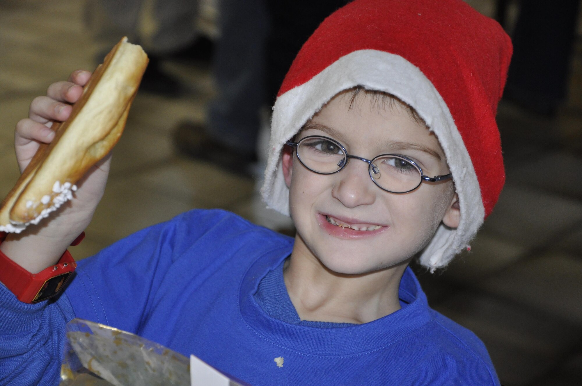 A boy enjoys a holiday treat during the annual Saint Nicholas celebration, held by the Bitburg Saint Martin school, Dec. 5 in Bitburg. The event included a visit by Saint Nicholas, dances and singing performances by the children as well as a gift presentation by the 52nd Fighter Wing. The celebration was attended by Saint Martin school officials, parents, 52nd Fighter Wing leadership spouses, as well as Airmen and civilians from the wing, who provided gifts to students and kindergarten children. In the summer,  Spangdahlem Sabers invited the Saint Martin school to Special Children’s Day at Spangdahlem AB, where they played games and spent a fun-filled time together. (U.S. Air Force photo by Iris Reiff)