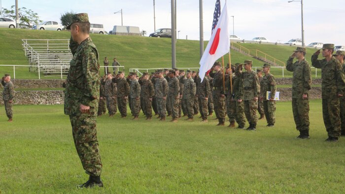 U.S. Marines with 3d Marine Expeditionary Brigade and service members of the Japan Ground Self-Defense Force salute the national colors of both nations at Camp Courtney, Okinawa, Japan, during the opening ceremony for Yama Sakura 71, Dec. 7, 2016,. The purpose of YS 71 is to enhance both nations’ combat readiness and interoperability while strengthening bilateral relationships and demonstrating U.S. resolve to support security interests of allies and partners in the Indo-Asia-Pacific region.