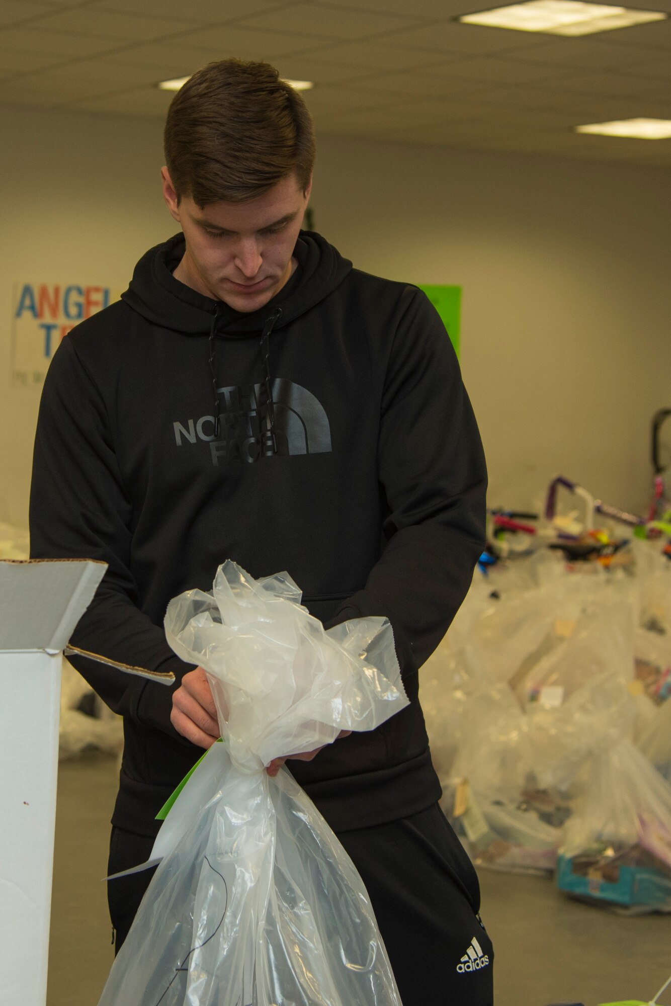 Senior Airman Jacob Whitfill, 811th Security Forces Squadron executive aircraft security member, attaches a tag to a bag filled with toys for the Salvation Army Angel Tree Program on Joint Base Andrews, Md., Dec. 8, 2016. The 811th SFS has been working for 2 years with the program that gives toys during the holidays for children of the less fortunate. (U.S. Air Force photo by Airman 1st Class Valentina Lopez)