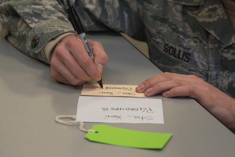 Staff Sgt. Brian Sollis, 811th Security Forces Squadron executive aircraft security member, writes on a gift label for the Salvation Army Angel Tree Program on Joint Base Andrews, Md., Dec. 8, 2016. Holiday gifts are donated to the program for children of low income families. (U.S. Air Force photo by Airman 1st Class Valentina Lopez)