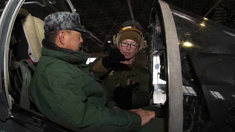 U.S. Marine Corps Lance Cpl. Jasaon Breker, a power line technician with Marine Attack Squadron (VMA) 542, explains how an AV-8B Harrier’s controls work inside the cockpit to a member of the Japan Air Self Defense Force at Chitose Air Base, Japan, Dec. 9, 2016. JASDF personnel joined the VMA-542 Marines in their hangar to get a closer look and better understanding of the squadrons Harriers. (U.S. Marine Corps photo by Lance Cpl. Joseph Abrego)