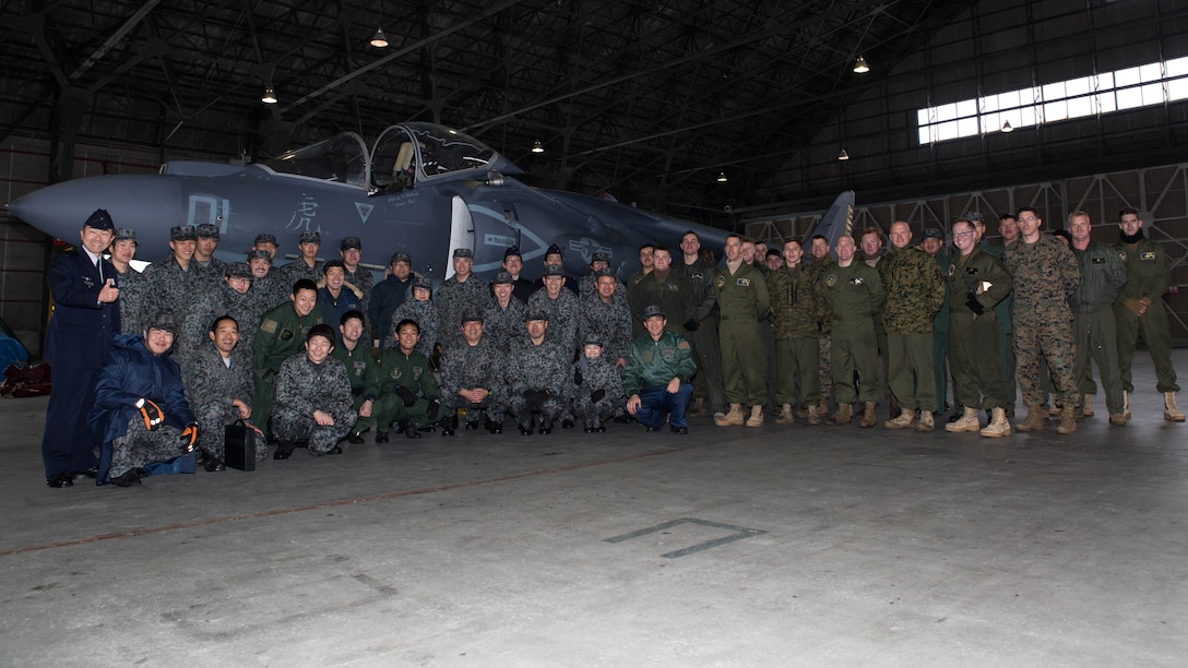 U.S. Marines with Marine Attack Squadron (VMA) 542 and Japan Air Self Defense Force personnel pose for a photo during the Aviation Training Relocation Program at Chitose Air Base, Japan, Dec. 9, 2016. JASDF personnel joined the VMA-542 Marines in their hangar to get a closer look and better understanding of the squadrons Harriers. (U.S. Marine Corps photo by Lance Cpl. Joseph Abrego)