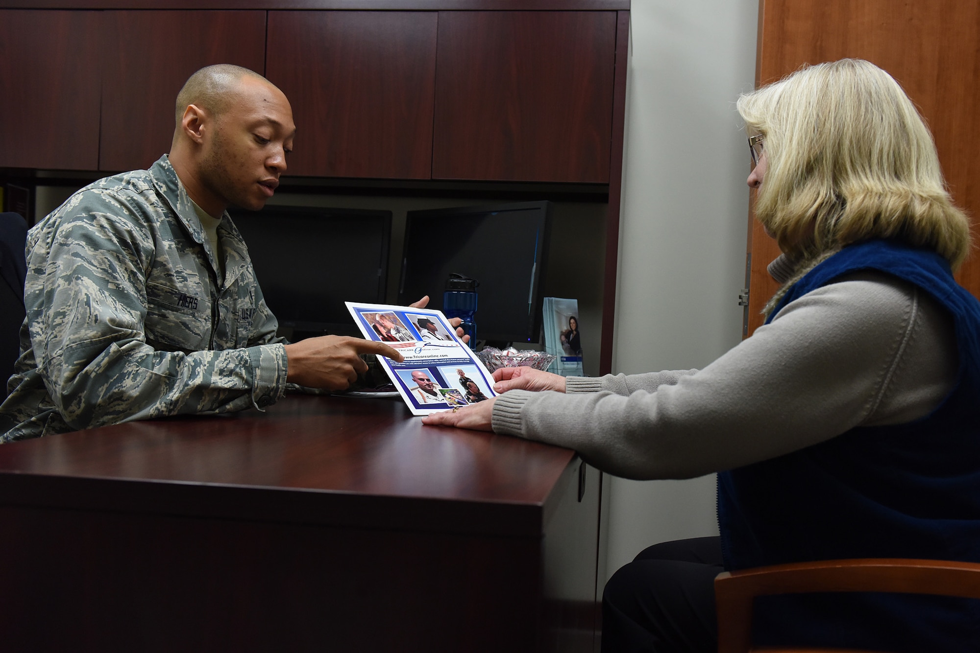 2nd Lt. Marques Hiers, 341st Medical Group Tricare operations and patient administration flight commander, discusses the benefits of using Tricare Online with a patient, Dec. 8, 2016.  Tricare Online is a web portal that allows patients to take care of their medical needs such as make appointments, look at their health record and send direct messages to their health care provider while online.  (U.S. Air Force photo/Jason Heavner)