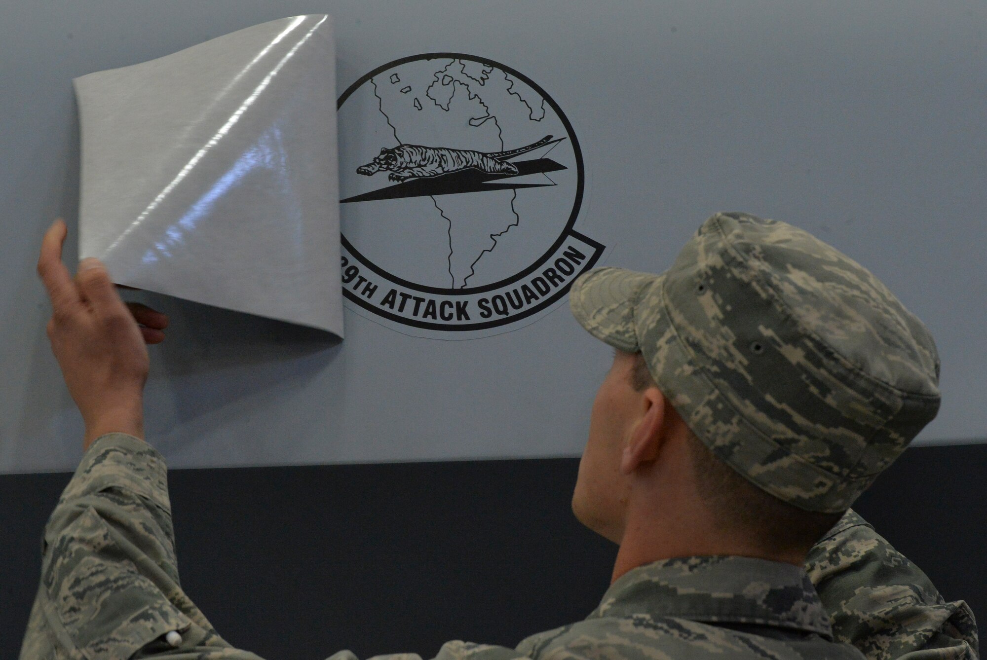 An Airman reveals the 489th Attack Squadron patch on an MQ-9 Reaper during the unit’s reactivation ceremony Dec. 2, 2016, at Creech Airforce Base, Nev. Lt. Col. Theodore assumed command of the 489th ATKS during the ceremony. (U.S. Air Force photo/ Airman 1st Class Kristan Campbell)