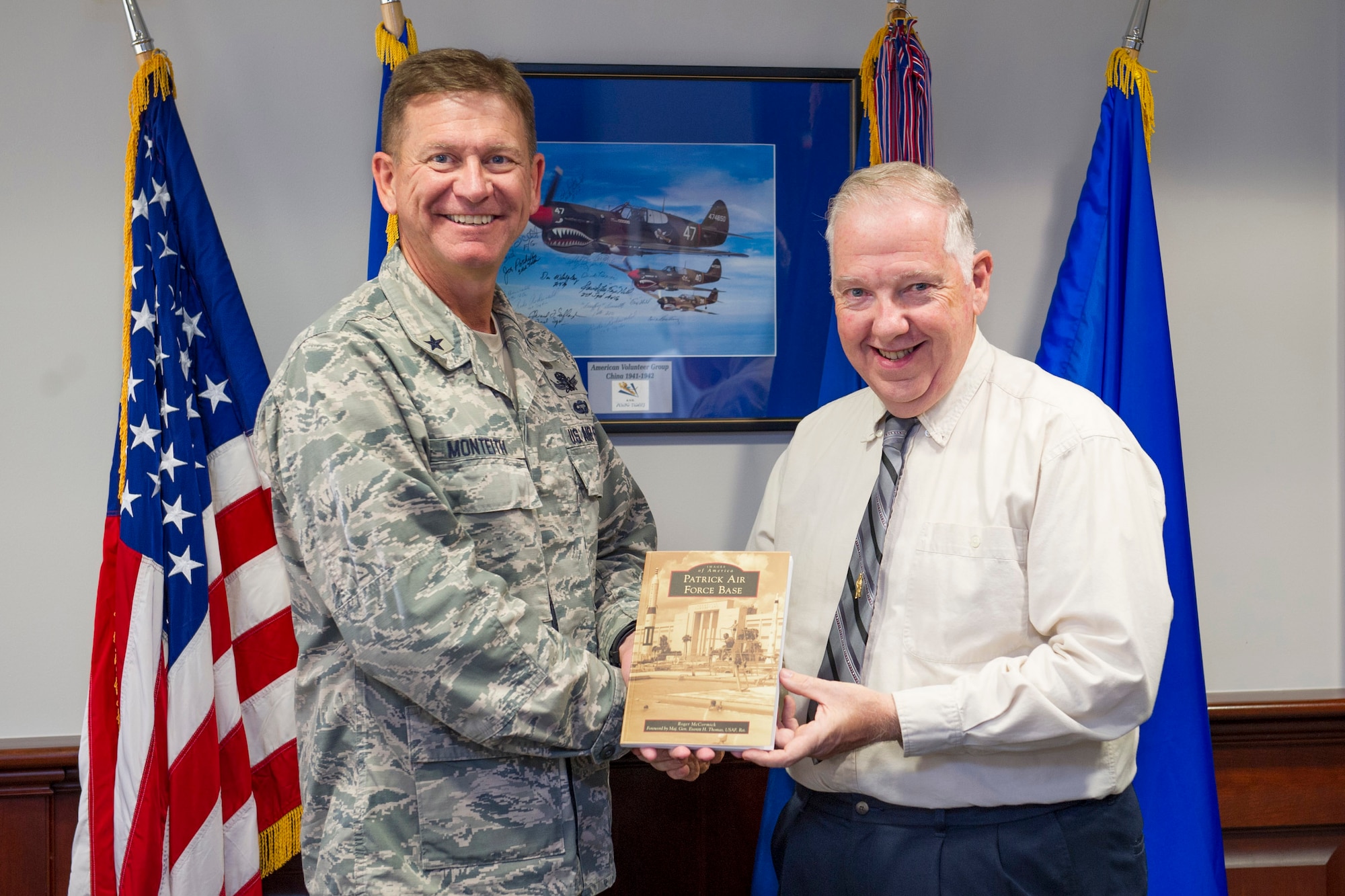Brig. Gen. Wayne Monteith, 45th Space Wing commander, is presented with a book titled: Images of America Patrick Air Force Base by Roger McCormick, author, and volunteer at the Sands Space History Center Dec. 8, 2016, at Patrick Air Force Base, Fla. Images from military and community archives, along with private collections, are used to tell the story of this historical base, which has the responsibility of managing a military airfield and a spaceport. (U.S. Air Force photo/Matthew Jurgens)