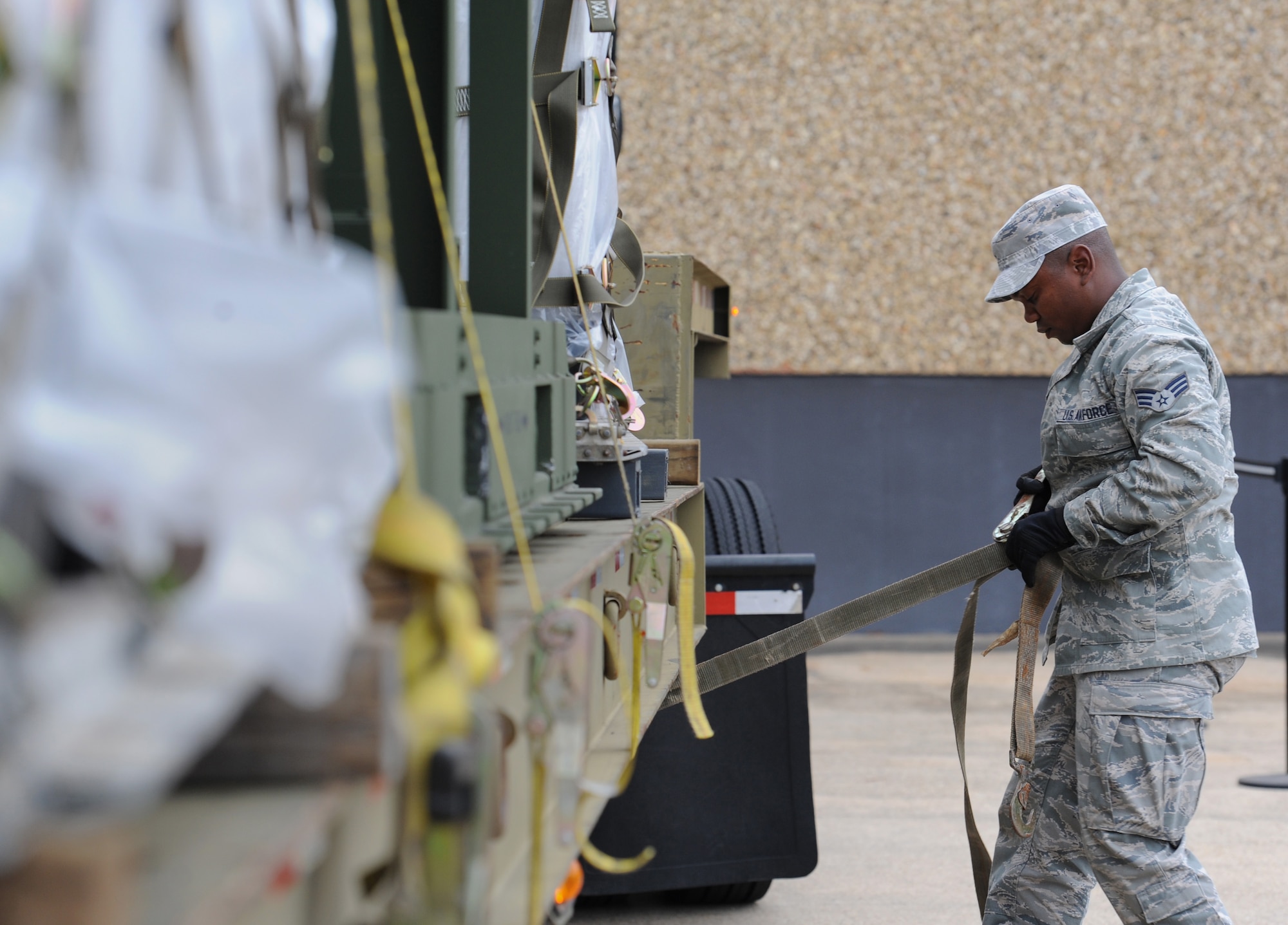 Senior Airman Mikhail Gordon, 81st Logistics Readiness Squadron vehicle operator, removes cargo straps at the supply warehouse loading docks during a deployment exercise Dec. 7, 2016, on Keesler Air Force Base, Miss. The exercise scenario tested the mission readiness of Team Keesler for simultaneous world-wide deployments. (U.S. Air Force photo by Kemberly Groue)