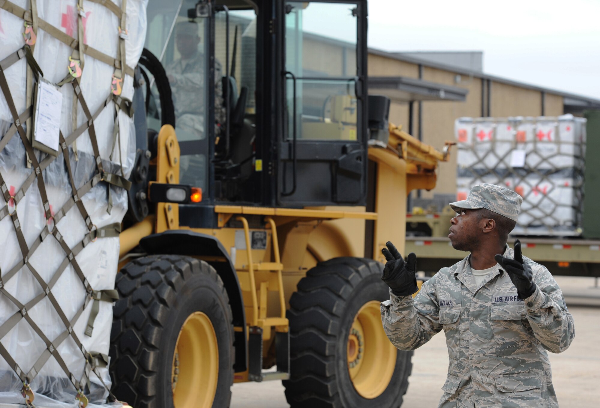 Staff Sgt. Junior Avilma, 81st Logistics Readiness Squadron vehicle operator, provides direction to Airman 1st Class David Whatley, 81st LRS vehicle maintainer, as he transports cargo at the supply warehouse loading docks during a deployment exercise Dec. 7, 2016, on Keesler Air Force Base, Miss. The exercise scenario tested the mission readiness of Team Keesler for simultaneous world-wide deployments. (U.S. Air Force photo by Kemberly Groue)