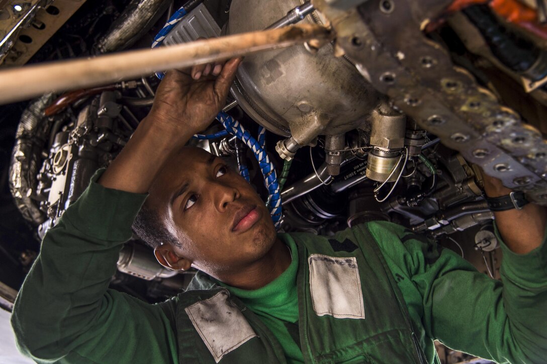 Navy Petty Officer 3rd Class Cesar Santana replaces a heat exchanger on an F/A-18C Hornet on the USS Dwight D. Eisenhower in the Red Sea, Dec. 2, 2016. Santana is an aviation machinist's mate. The Hornet is assigned to Strike Fighter Squadron 131. The aircraft carrier is supporting Operation Inherent Resolve, maritime security operations and theater security cooperation efforts in the U.S. 5th Fleet area of operations. Navy photo by Petty Officer 3rd Class Nathan T. Beard