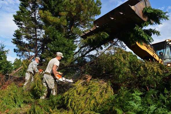 Staff Sgt. Sonny Tanner and Senior Airman Reid Johanns use chainsaws to cut trees while Staff Sgt. Claudas Crenshaw operates a front-end loader to pick up the debris at Shaw Air Force Base, S.C., Dec. 5, 2016. The a 20th Civil Engineer Squadron’s heavy equipment flight has cleaned up approximately 300 trees around Shaw that were damaged or uprooted during Hurricane Matthew. (U.S. Air Force photo/Airman 1st Class Destinee Sweeney)
