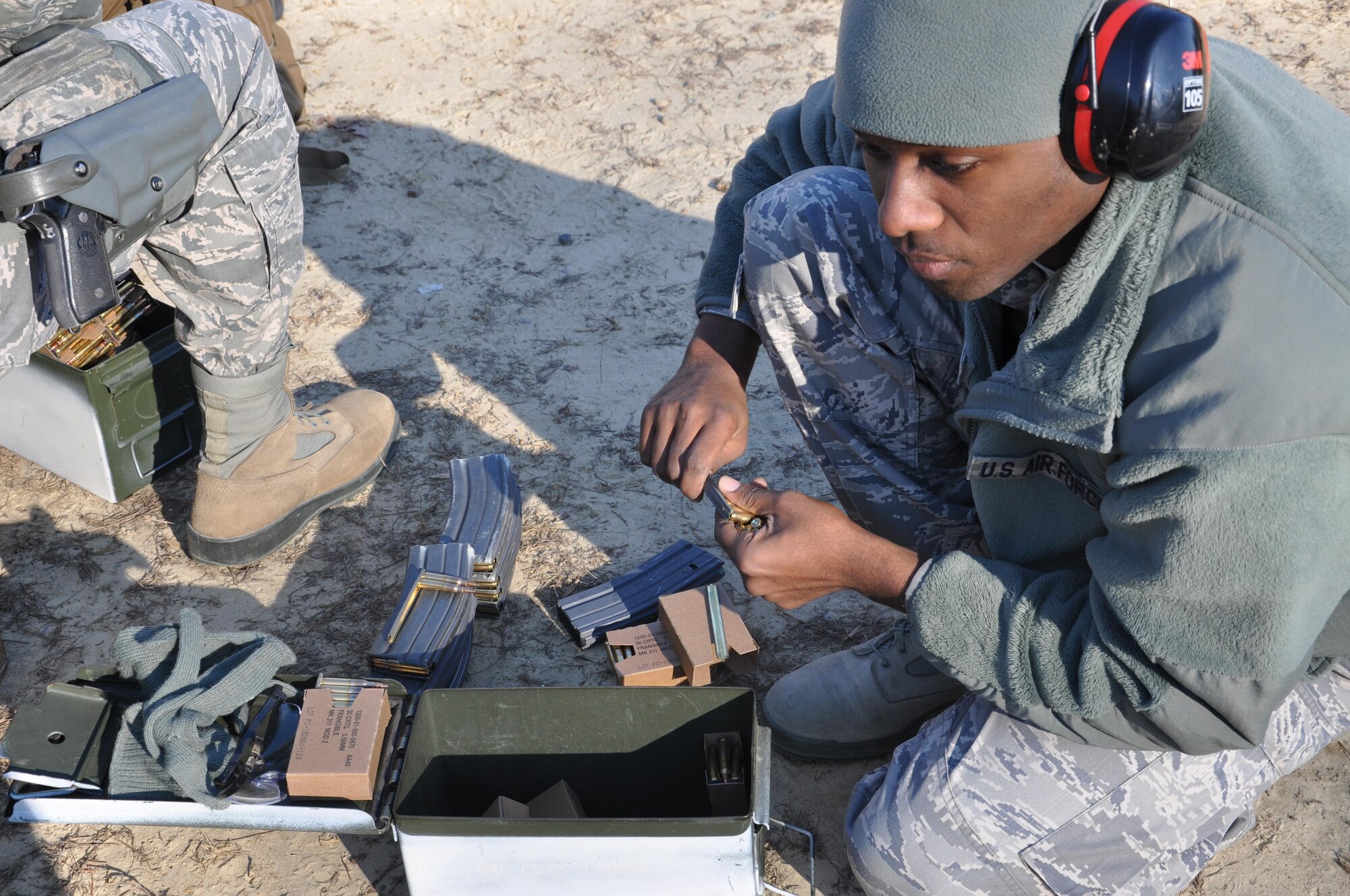 A member of the 459th Security Forces Squadron loads bullets into a clip prior to M4 assault rifle and M9 handgun training at Marine Corps Base Quantico, Virginia, firing range Dec. 3, 2016. To keep their qualification members are required to take 45 shots at various distances and positions hitting the target at least 35 times. (U.S. Air Force photo/Senior Airman Kristin Kurtz)