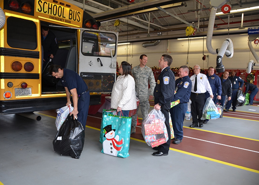 Defense Logistics Agency Installation Support at Richmond’s Fire and EMS personnel and Defense Supply Center Richmond, Virginia, volunteers load a bus with gifts for 113 angels Dec. 8, 2016.  Employees adopted angels from Chesterfield County and Richmond City Public Schools. 