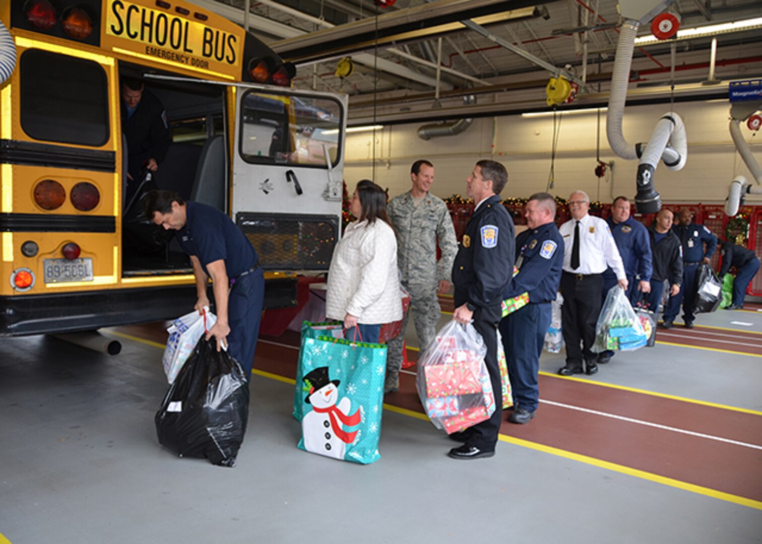 Defense Logistics Agency Installation Support at Richmond’s Fire and EMS personnel and Defense Supply Center Richmond, Virginia, volunteers load a bus with gifts for 113 angels Dec. 8, 2016.  Employees adopted angels from Chesterfield County and Richmond City Public Schools. 