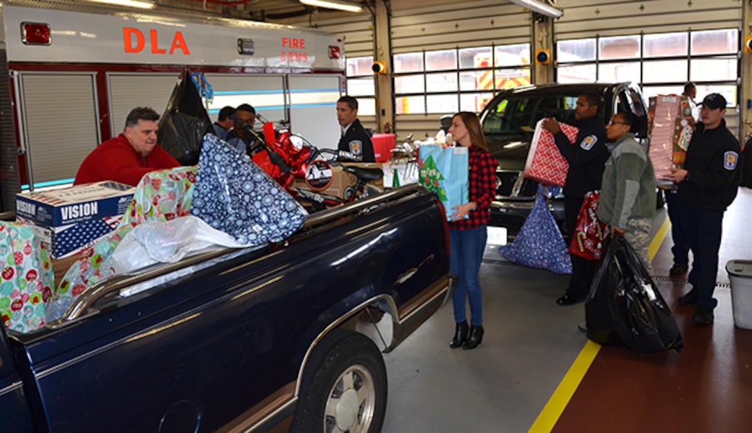 Defense Logistics Agency Installation Support at Richmond’s Fire and EMS personnel and Defense Supply Center Richmond, Virginia, volunteers load pickup trucks with gifts for 113 angels Dec. 8, 2016 at the center’s fire station.  Employees adopted angels from Chesterfield County and Richmond City Public Schools. 