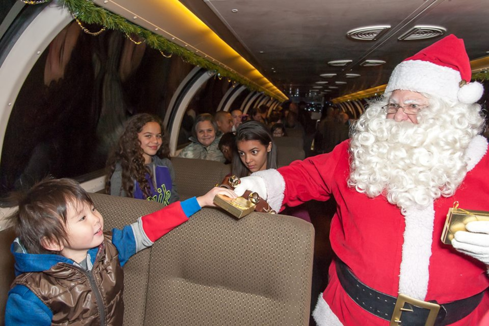 Santa Claus gives a young passenger aboard the Holiday Express a small gift. Burlington Northern and Santa Fe Railway Company, a nationwide freight transportation company, has been running its Holiday Express for the past eight years to give members of the military and their families the experience of riding a train. About 300 people experienced the holiday train ride. 