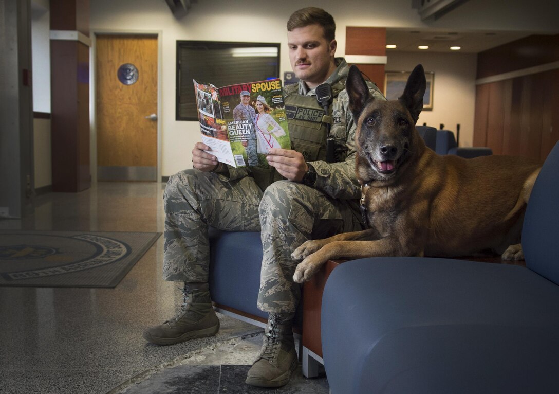Staff Sgt. Derek Scrivener, 11th Security Forces Squadron military working dog handler, sits for a photo while waiting to complete a practice sweep with MWD Lenox the passenger terminal on Joint Base Andrews, Md., Dec. 8, 2016.  MWD’s work as force multipliers, using their senses in low-visibility situations to acknowledge things a handler might not see. (U.S. Air Force photo illustration by Senior Airman Mariah Haddenham)