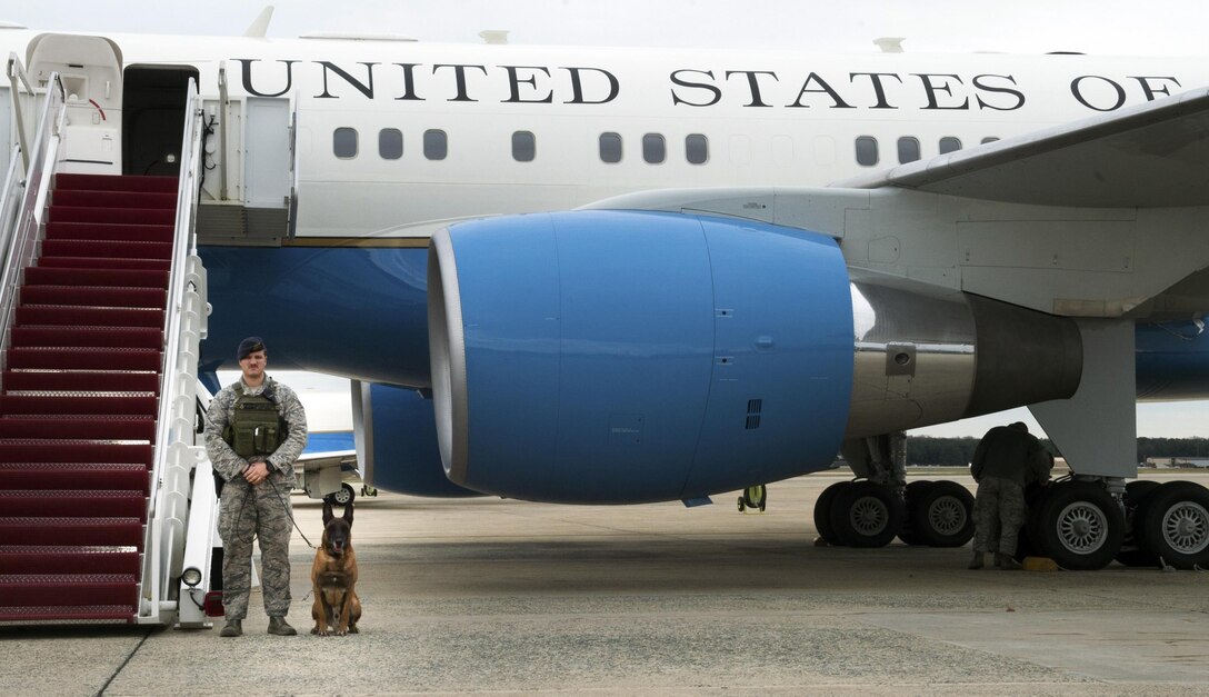 Staff Sgt. Derek Scrivener, 11th Security Forces Squadron military working dog handler, stands for a photo with MWD Lenox at Joint Base Andrews, Md., Dec. 8, 2016.  MWD’s work as force multipliers, using their senses in low-visibility situations to acknowledge things a handler might not see and keeping aircraft safe. (U.S. Air Force photo by Senior Airman Mariah Haddenham)