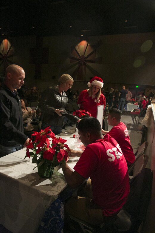 Lance Cpl. Alberto Vasquez, team leader, and Lance Cpl. Hector Tecuanhuey, rifleman, 3rd Light Armored Reconnaissance Battalion, hand out raffle tickets for Marine Corps Community Service’s Motor Mania Giveaway during the Combat Center Holiday Show at Sunset Cinema aboard Marine Corps Air Ground Combat Center, Twentynine Palms, Calif., Dec. 3, 2016. (Official Marine Corps photo by Lance Cpl. Dave Flores/Released)