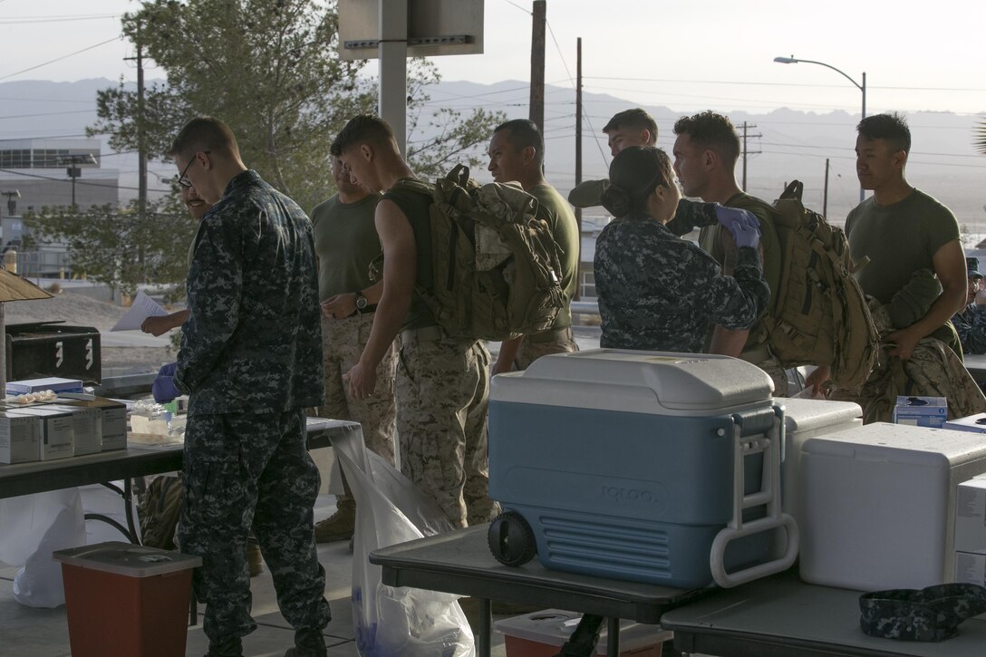 Navy corpsmen give students of Marine Corps Communication-Electronics School influenza vaccines during the Naval Hospital Twentynine Palms point of dispensing exercise at building 1661, Nov. 6, 2016. The exercise trains the corpsman on how to quickly and efficiently distribute vaccines during a pandemic. (Official Marine Corps photo by Cpl. Thomas Mudd/Released)