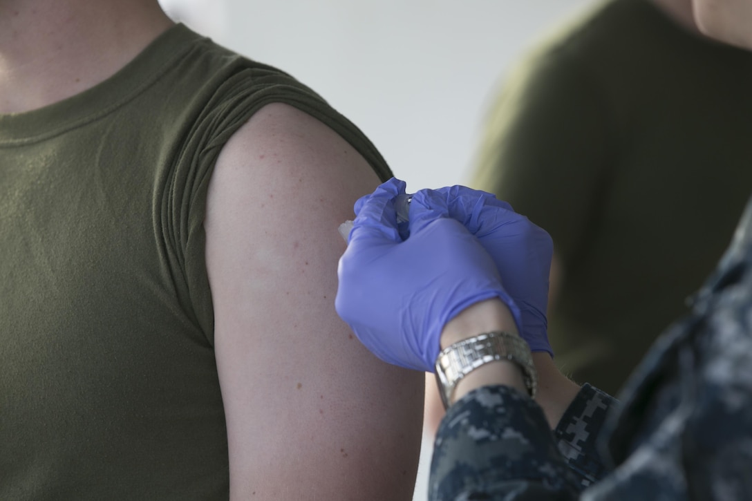A Navy corpsman administers a vaccine to a Marine during the Naval Hospital Twentynine Palms point of dispensing exercise at building 1661, Nov. 6, 2016. The exercise trains the corpsman on how to quickly and efficiently distribute vaccines during a pandemic. (Official Marine Corps photo by Cpl. Thomas Mudd/Released)