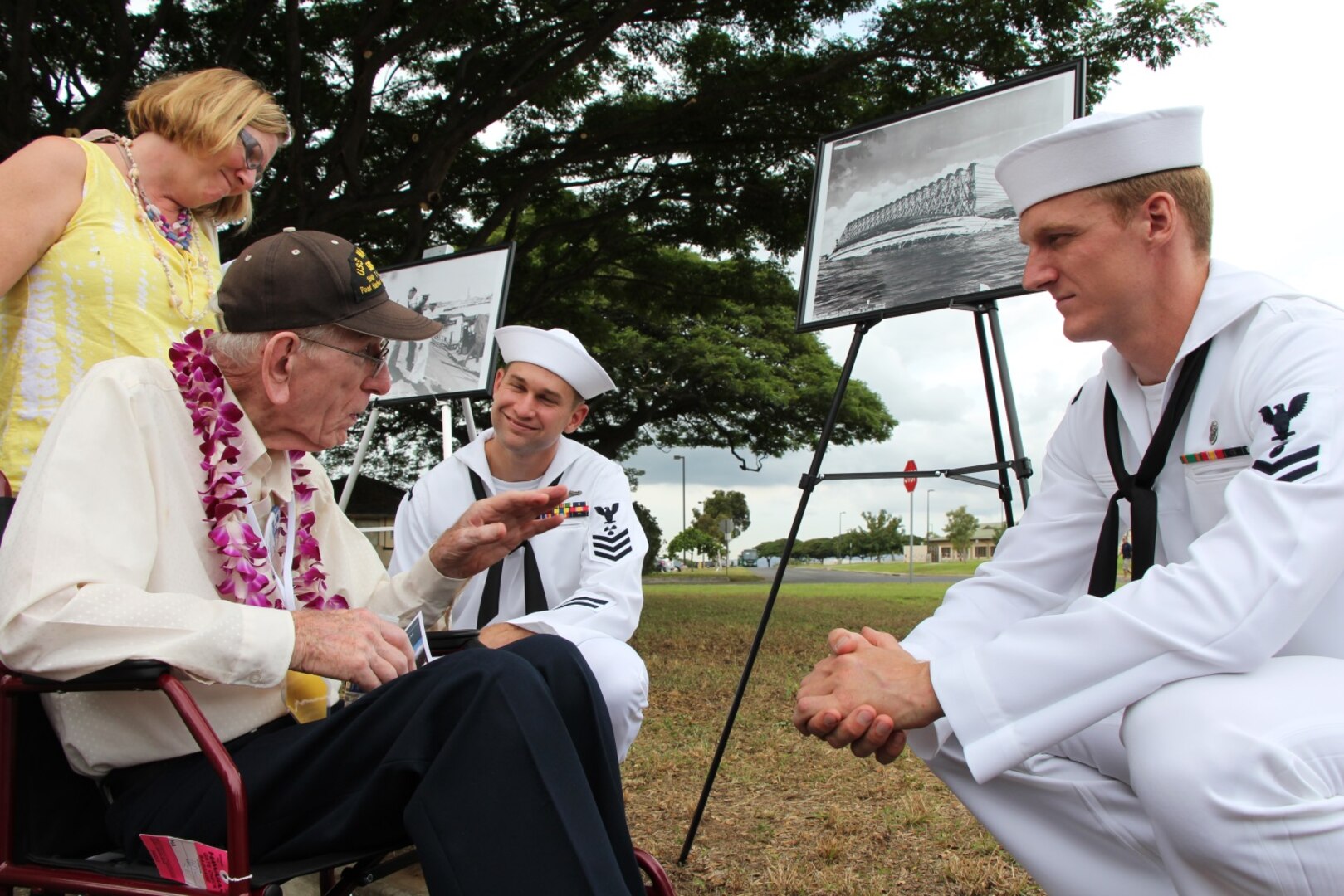 PEARL HARBOR, Hi. (Dec. 7, 2016) Former USS Maryland (BB-46) crew member and Pearl Harbor survivor Electricians Mate Floyd Welch and his daughter Laurie Broglio, share memories with Petty Officer 1st Class Thomas McMillian and Petty Officer 2nd Class Kristian Cheeks during the Dec. 7 USS Oklahoma Memorial Ceremony on Ford Island.  Petty Officers McMillian and Cheeks, both assigned to Pearl Harbor Naval Shipyard & Intermediate Maintenance Facility (PHNSY & IMF) were part of a detail which displayed photos tracking the salvage of USS Oklahoma following the attacks of Dec. 7, 1941.