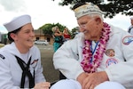 PEARL HARBOR, Hi. (Dec. 7, 2016) Seaman Rachel Johnson listens as former USS Maryland (BB-37) crew member and Pearl Harbor survivor Peter Nichols, share memories during the Dec. 7 USS Oklahoma Memorial Ceremony on Ford Island.  Seaman Johnson, assigned to Pearl Harbor Naval Shipyard & Intermediate Maintenance Facility (PHNSY & IMF) was part of a detail which displayed photos tracking the salvage of USS Oklahoma following the attacks of Dec. 7, 1941.