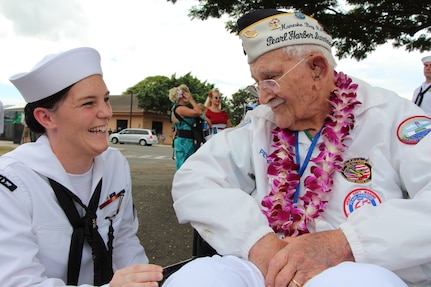 PEARL HARBOR, Hi. (Dec. 7, 2016) Seaman Rachel Johnson listens as former USS Maryland (BB-37) crew member and Pearl Harbor survivor Peter Nichols, share memories during the Dec. 7 USS Oklahoma Memorial Ceremony on Ford Island.  Seaman Johnson, assigned to Pearl Harbor Naval Shipyard & Intermediate Maintenance Facility (PHNSY & IMF) was part of a detail which displayed photos tracking the salvage of USS Oklahoma following the attacks of Dec. 7, 1941.