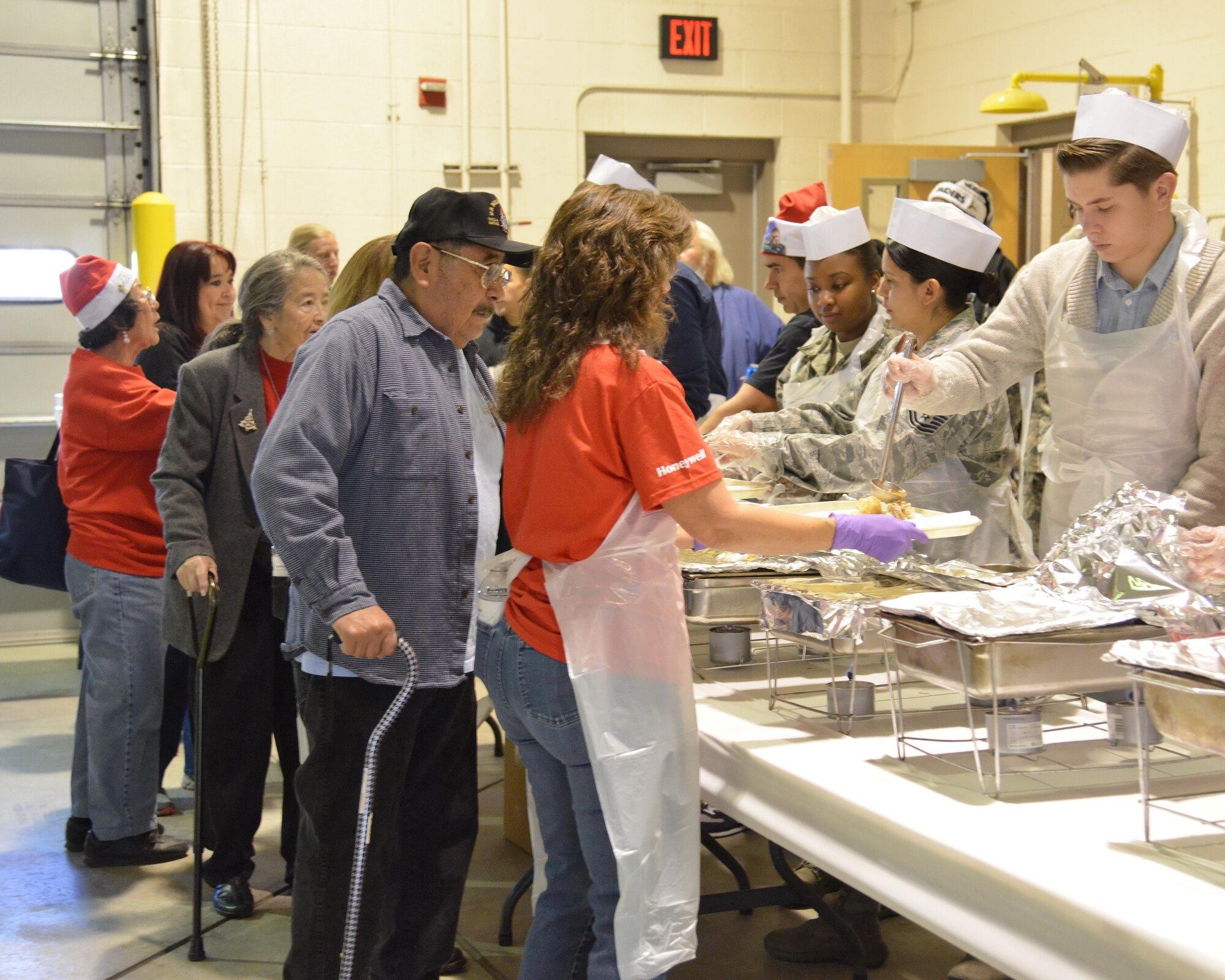 Members of the community fill their plates at the 2015 Operation Holiday Cheer event.  The event is hosted annually by the Kirtland Fire Department and is in its 38th year. Attendees get a turkey dinner and a chance to participate in a number of activities. Santa visits each year and gives out about 1,000 toys. This year's event will take place Dec. 14