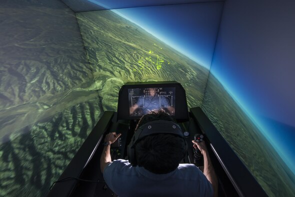 Zach Demers, an aerospace engineer, demonstrates the Automatic Ground Collision Avoidance System (Auto GCAS) in an F-16 flight simulator at the Air Force Research Laboratory, Wright-Patterson Air Force Base, Ohio, April 18. Auto GCAS, which constantly compares the aircraft's speed and position to a digital terrain map and will automatically take control if it detects an imminent ground collision, is credited with saving the lives of four pilots. (U.S. Air Force photo/Master Sgt. Brian Ferguson)
