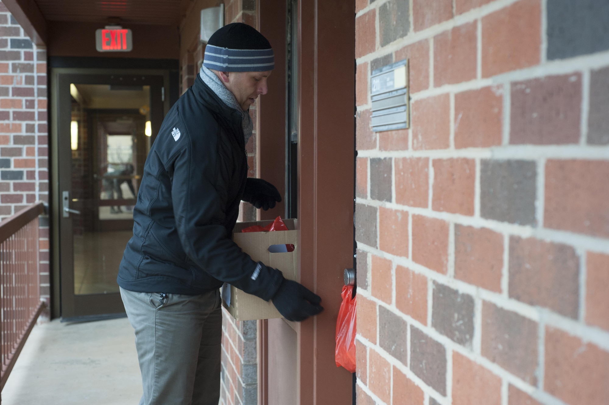 U.S. Air Force Master Sgt. Eric Siemsen, 317th Operation Support Squadron first sergeant, hangs a bag of cookies for a dorm resident as part of Operation Cookie Drop at Dyess Air Force Base, Texas Dec. 9, 2016. More than 7,000 cookies were donated for the event from Dyess leadership, spouses and various organizations from the Abilene community. (U.S. Air Force photo by Airman 1st Class Rebecca Van Syoc)