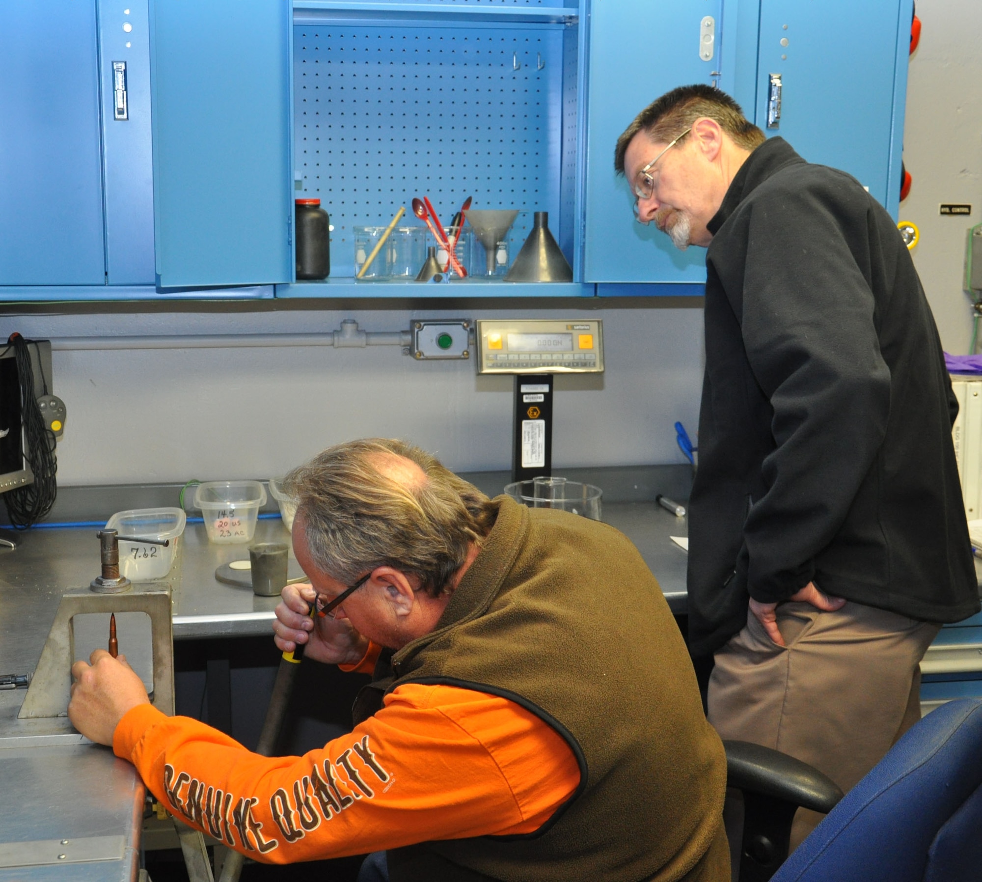 Scott Ehman, lead range safety officer at the 96th Test Group's test facility in Area B, downloads a small arms round to achieve desired velocity for a test of foreign munitions impact on U.S. aircraft as William Curtis, Wright-Patterson's Weapons Safety Program Manager observes. (U.S. Air Force photo/Bryan Ripple)
