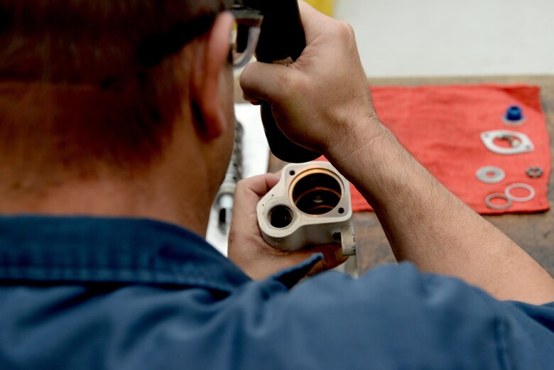 Ronald Roman, 97th Maintenance Directorate hydraulics mechanic, checks a U.S. Air Force KC-135 Stratotanker selector valve for fluid, Nov. 11, 2016, Altus Air Force Base, Oklahoma. The valve is used to direct hydraulic fluid under pressure to raise or lower landing gear for takeoff and landing. (U.S. Air Force Photo by Airman Jackson N. Haddon/Released).