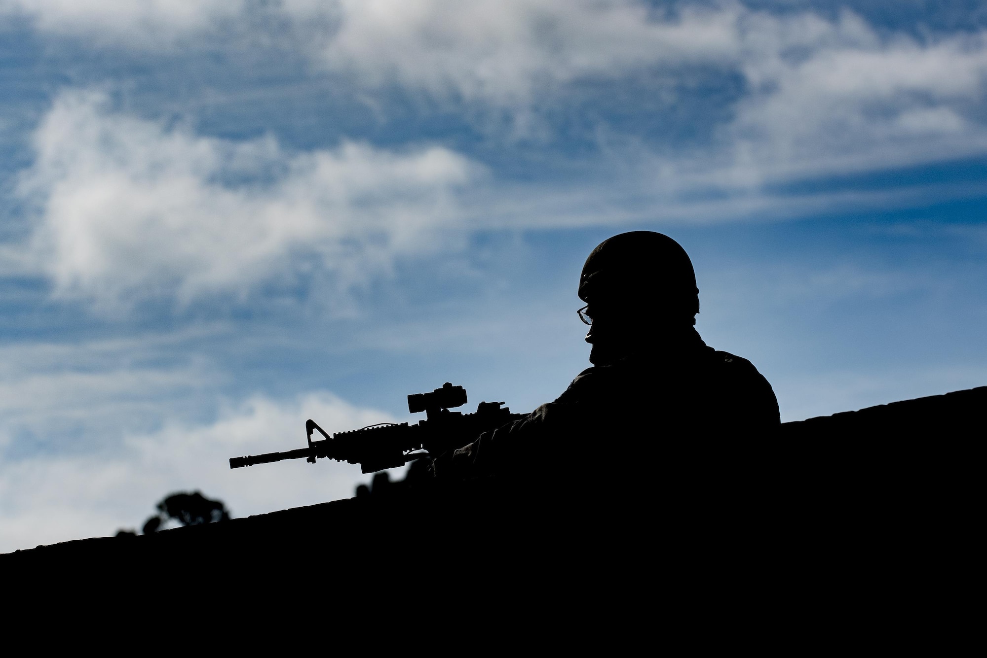 Tech. Sgt. Gregory Nickels, 23d Security Forces Squadron NCO in charge of the information fusion cell, surveys the scene over a brick wall during an active shooter exercise, Dec. 8, 2016, at Moody Air Force Base, Ga. Airmen and civilian personnel conducted lockdown procedures for approximately 1 hour and 30 minutes. (U.S. Air Force photo by Airman 1st Class Daniel Snider)