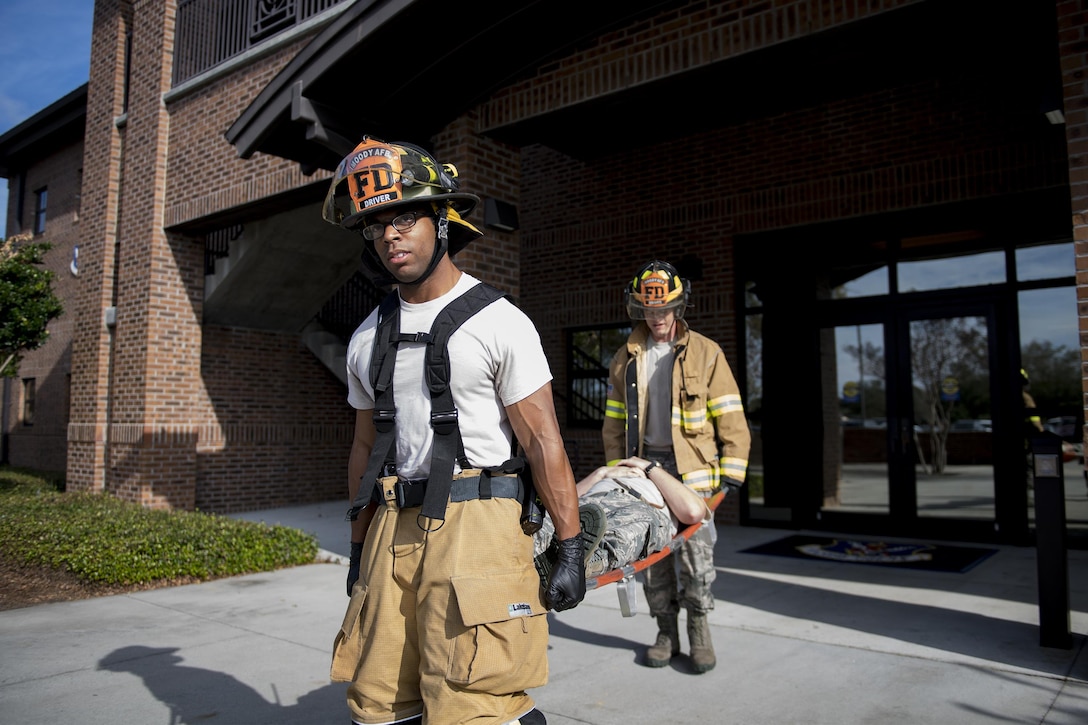 Senior Airmen Aaron Carpenter, left, and Cody Jones, 23d Component Maintenance Squadron driver operators, carry a simulated casualty away from the crime scene during an active shooter exercise, Dec. 8, 2016, at Moody Air Force Base, Ga. Firefighters and paramedics arrived to assist the injured after the scene was declared safe. (U.S. Air Force photo by Airman 1st Class Daniel Snider)